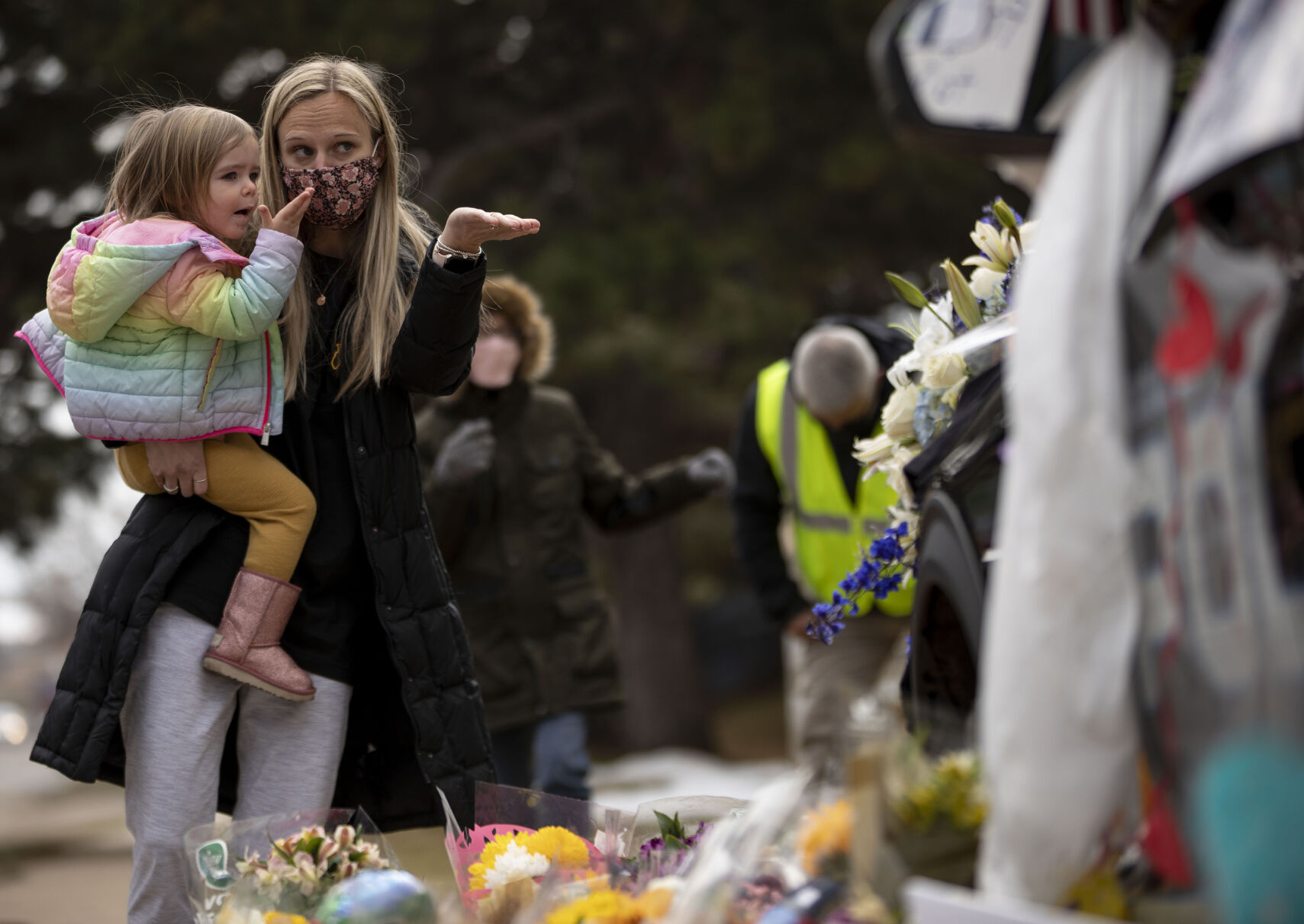 Courtney Shearon holds her daughter Charlotte, 2, as they blow a kiss in honor of officer Eric Talley, who was killed in a mass shooting with nine others at King Soopers supermarket on Monday, outside the Boulder Police Department in Boulder, Colo., on Wednesday, March 24, 2021. Community members payed their respects to officer Talley by leaving flowers and other items on his patrol car outside the station.(Chancey Bush/ The Gazette) (Chancey Bush)