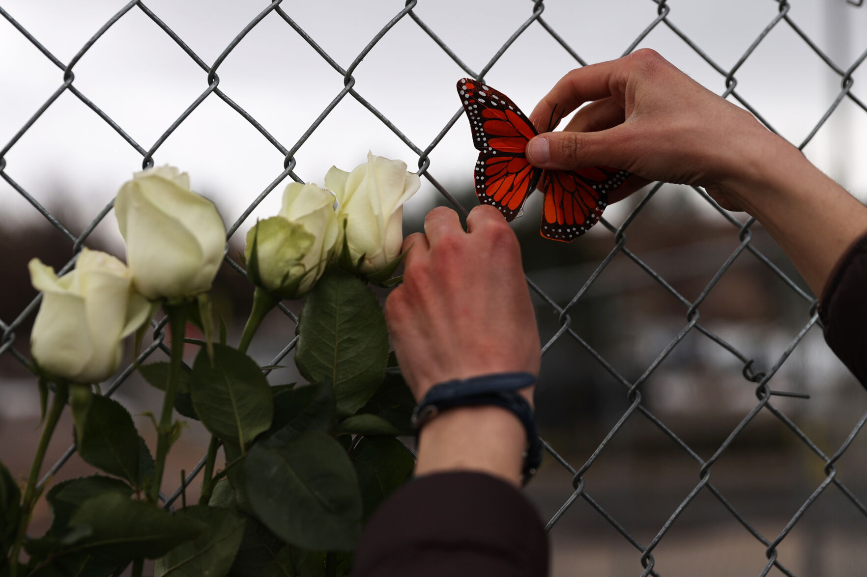Kathleen Salmon attaches some decorate butterflies to the flowers on the memorial at the King Soopers on Table Mesa Drive in Boulder on March 23, 2021. A gunman killed 10 people in a mass shooting at the store the day before. (Forrest Czarnecki/The Gazette) (Forrest Czarnecki)