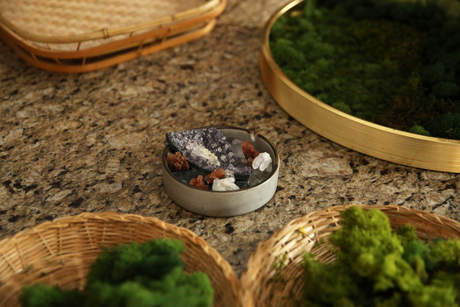 Crystals and stones are sometimes used as centerpieces in Courtney Arnstein's moss artwork. Here, a basket of crystals sits on the work table at her home in Colorado Springs on Feb. 12, 2021. (Forrest Czarnecki/The Gazette) (Forrest Czarnecki/The Gazette)