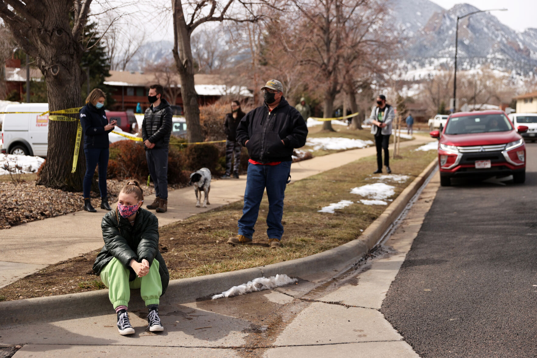Io Hartman, a photographer with The CU Independent, takes a moment to reflect on the curb outside the King Soopers on Table Mesa Drive in Boulder on March 23, 2021. A gunman killed 10 people in a mass shooting at the store the day before. (Forrest Czarnecki/The Gazette) (Forrest Czarnecki)