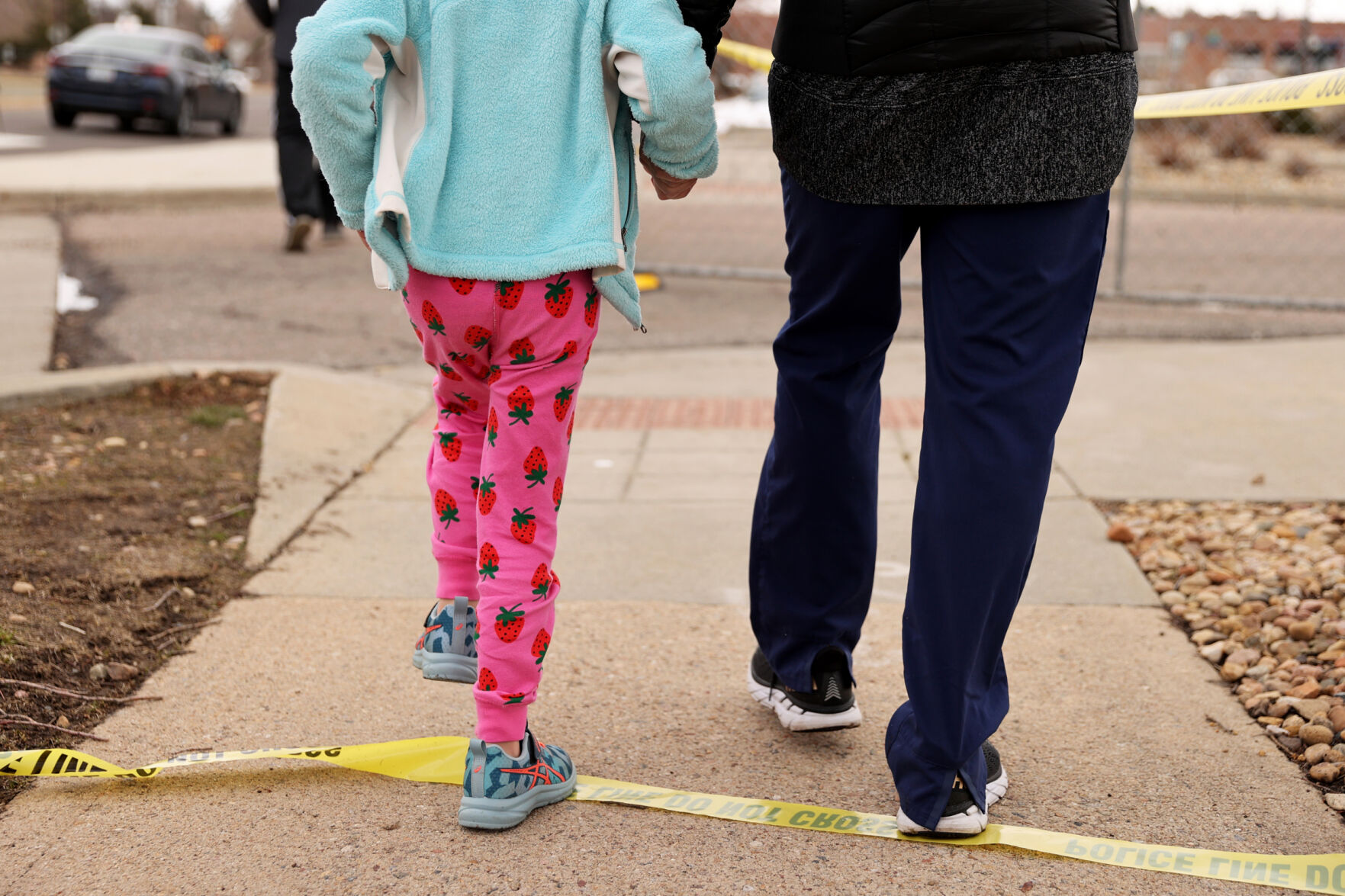 Charlie, left, and Cheryl Roy, right, step over a section of police tape while visiting a makeshift memorial at the King Soopers off Table Mesa Drive in Boulder on March 23, 2021. A gunman killed 10 people in a mass shooting at the store the day before. (Forrest Czarnecki/The Gazette) (Forrest Czarnecki)