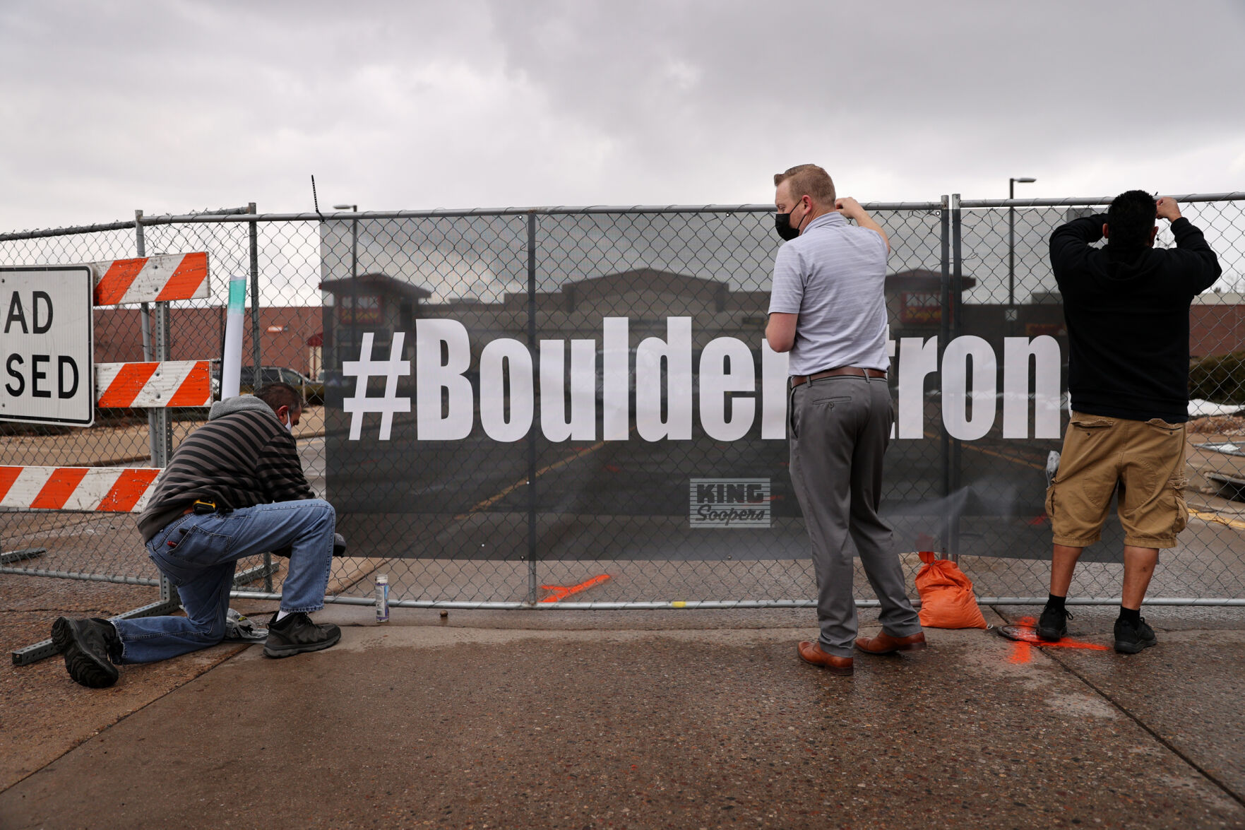 From left, Armando Montano, Mark Zwingelberg and Al Medina affix a banner with the #BoulderStrong message to the perimeter fence at the King Soopers on Table Mesa Drive in Boulder on March 23, 2021. A gunman killed 10 people in a mass shooting at the store the day before. (Forrest Czarnecki/The Gazette) (Forrest Czarnecki)