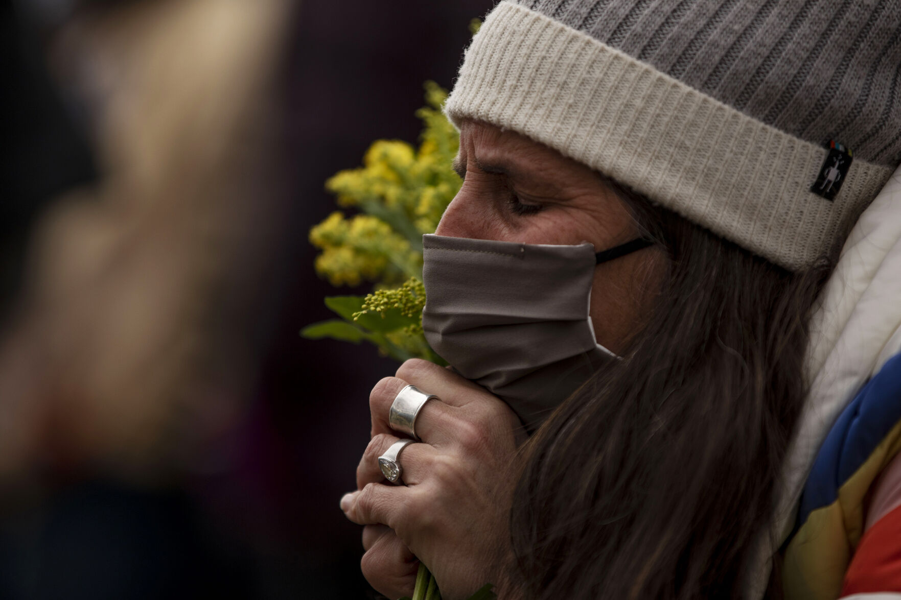 Osha Waters places flowers on a cross for Tralona Bartkowiak, who was one of 10 killed including a police officer in a mass shooting at King Soopers supermarket on Monday, outside the fence in font of the store in Boulder, Colo., on Wednesday, March 24, 2021. (Chancey Bush/ The Gazette) (Chancey Bush)