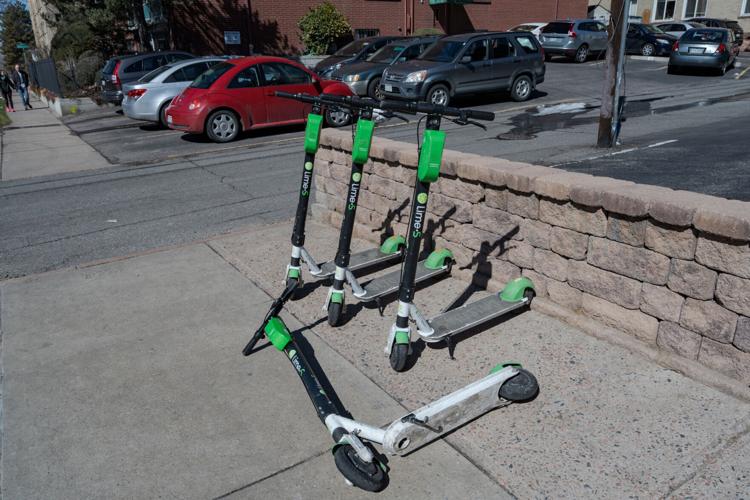 E-scooters on a side walk in Denver's Capitol Hill Neighborhood. 4 scooters, 3 standing 1 knocked down. (copy)