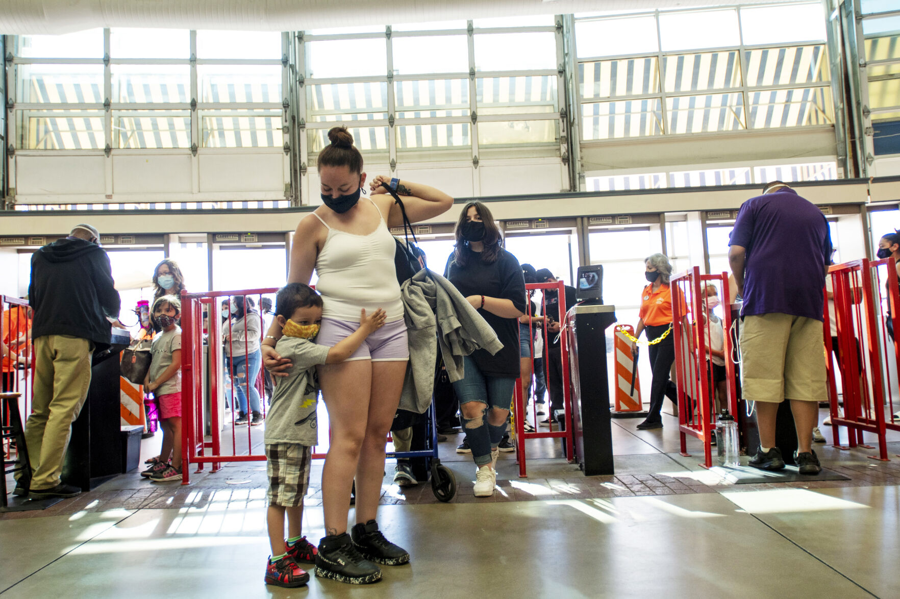 Isaiah, 4, hugs his mother Krystal Medina as they enter the park for opening day at Elitch Gardens in Denver, Colo., on Saturday, May 1, 2021. The amusement park opened for the first time since Nov. 3, 2019, at 43% of their normal capacity without the water park. (Chancey Bush/ The Gazette) (Chancey Bush/ The Gazette)