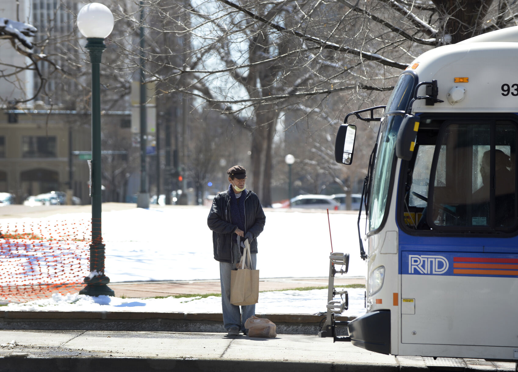 A rider waits for an eastbound RTD bus on East Colfax Avenue at Lincoln Street in Denver on April 17, 2020. ((Photo By Kathryn Scott))