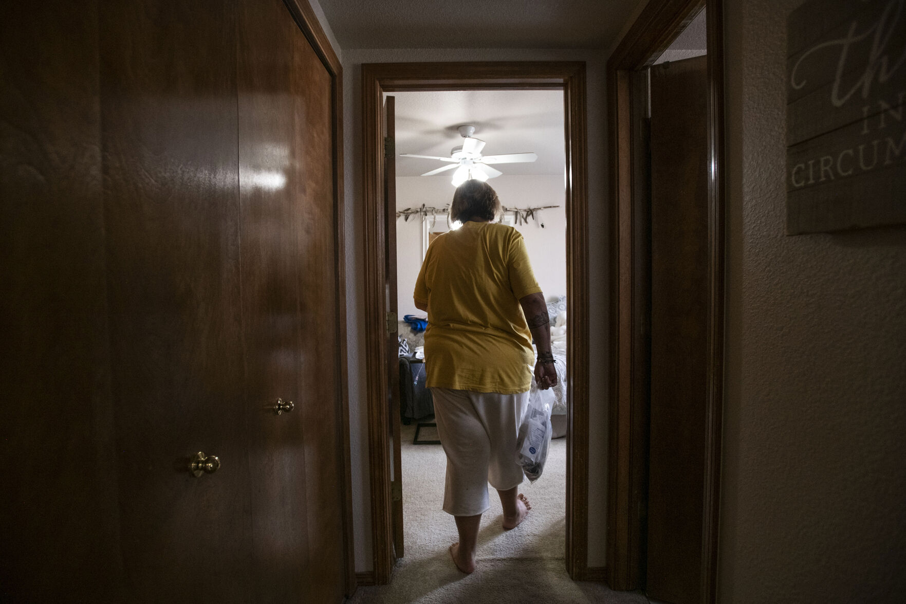 Kendra Lippy, 38, walks into her room to change her TPN bag, which she needs to deliver nutrient intravenously, in Colorado Springs on May 19, 2020. Her younger sister, Brenna Logan helps her change her TPN bag every evening. (Chancey Bush/ The Gazette) (Chancey Bush/ The Gazette)