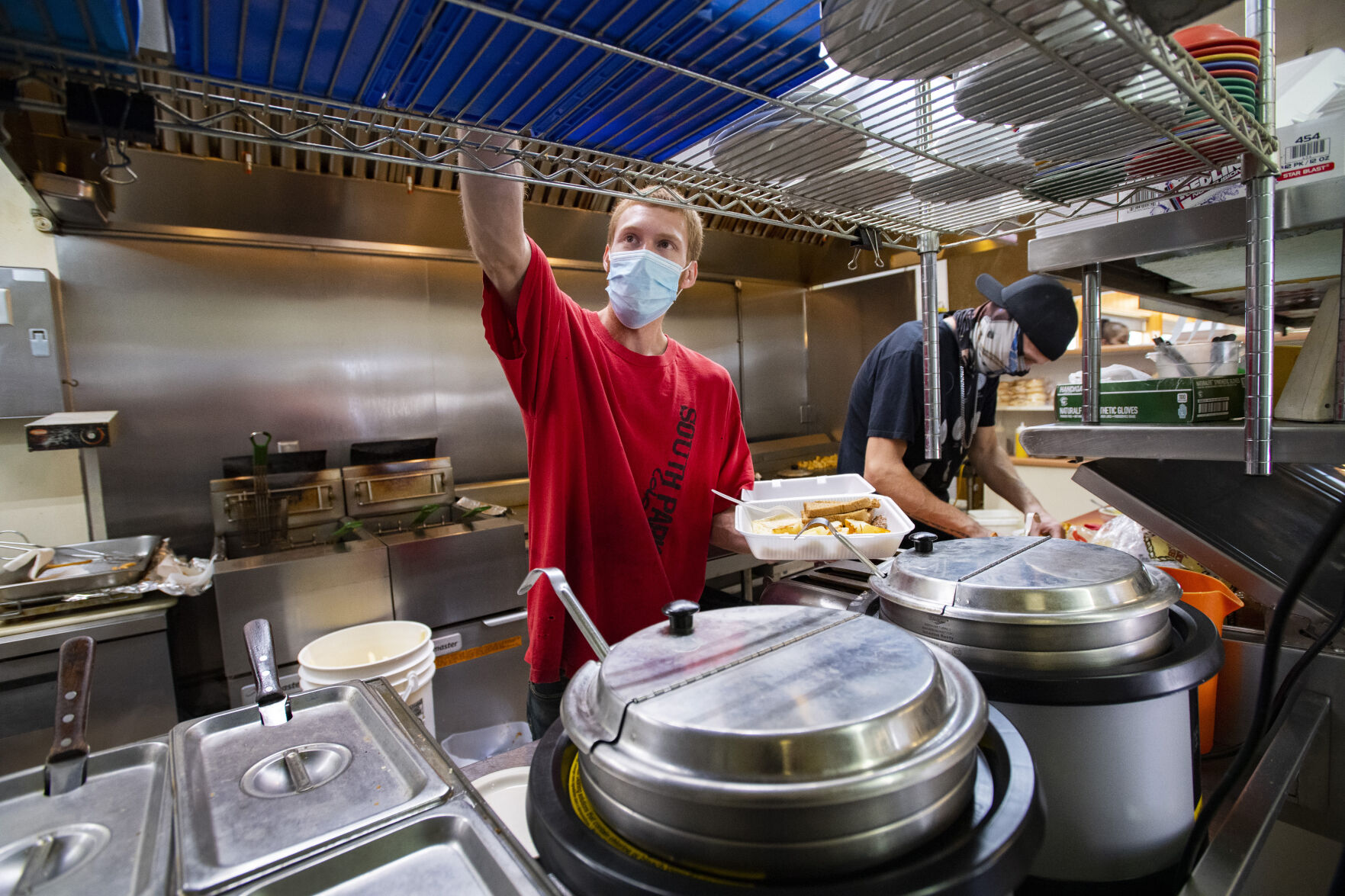 Cooks Tanner Bowman, left, and Bryan Thomas work the kitchen during the breakfast rush at George’s Drive Inn last month in Walsenburg. (Christian Murdock/The Gazette)