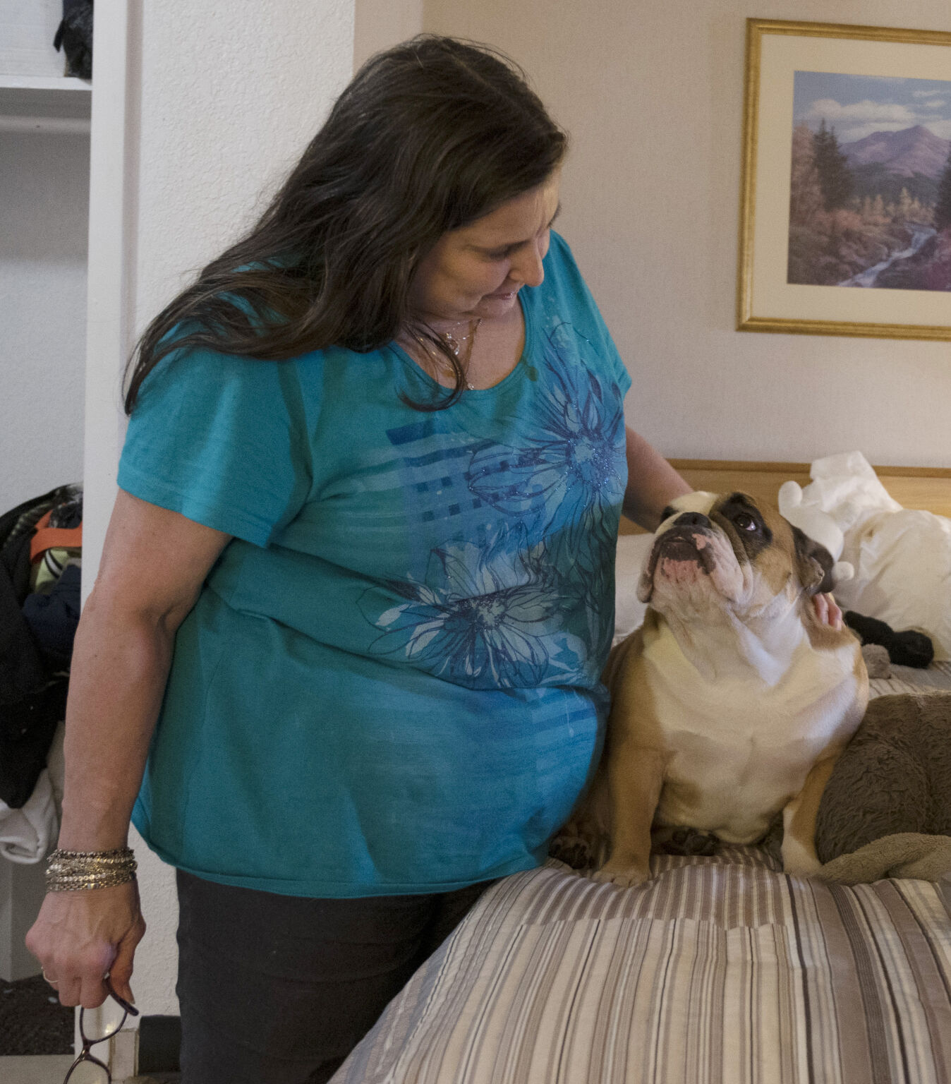 Denise Wilson pets her dog, Tinsel, in the motel where she and her family are currently living on Thursday, May 13, 2021. Last Fall, the family was spared from eviction of their 2-bedroom apartment where they had lived for 13 years when Gov. Jared Polis signed an executive order protecting tenants who have been impacted by COVID-19. Since then, they were recently evicted and have been living in a S. Nevada Ave. motel for two weeks. (JERILEE BENNETT THE GAZETTE)