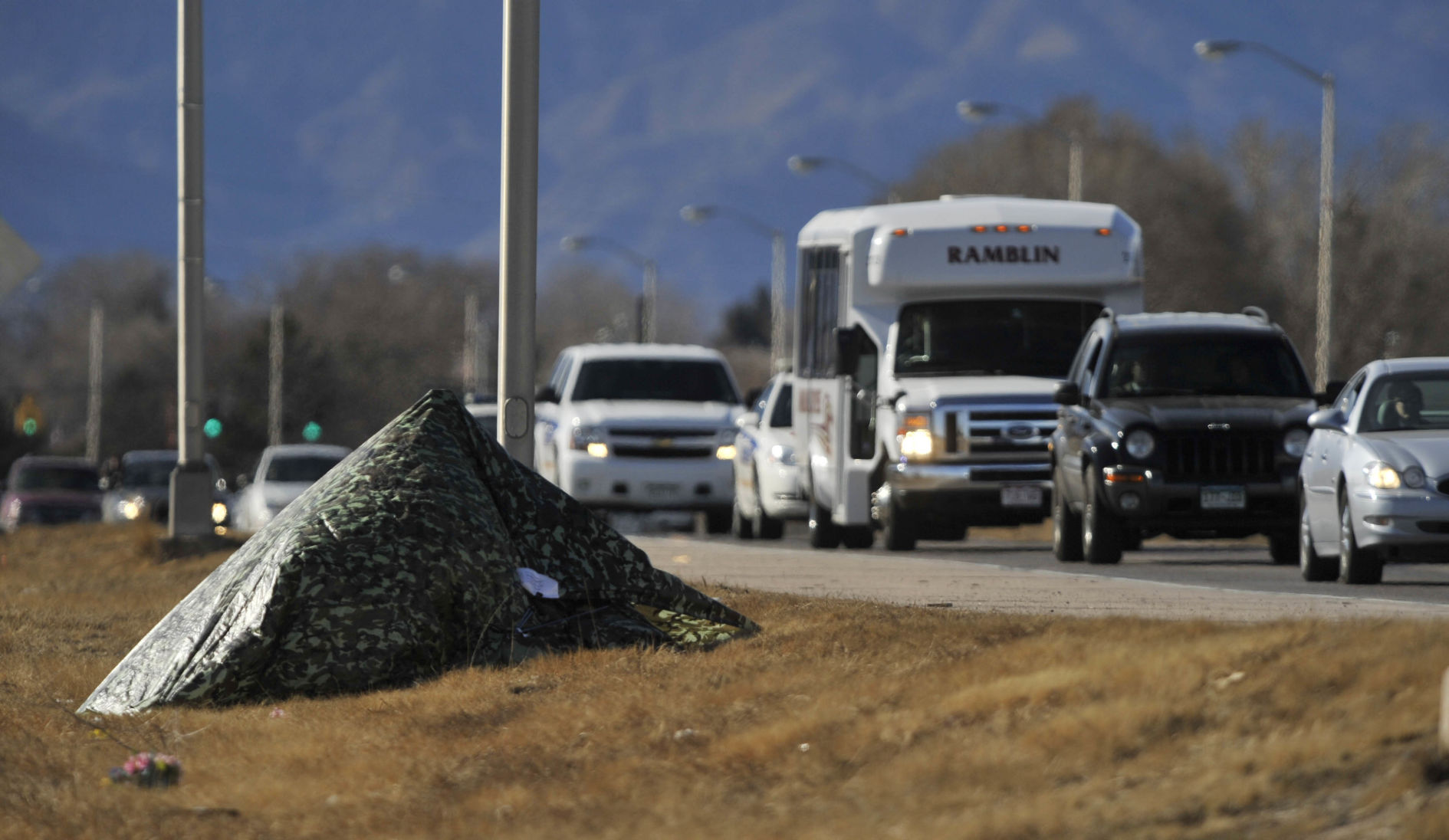Jurors in the Detra Farries trial ride in a bus along Platte Avenue Tuesday, February 14, 2012 past a roadside memorial to Allen Lew Rose that was covered by a tarp Tuesday by the District Attorney's Office. Mark Reis, The Gazette (MARK REIS)