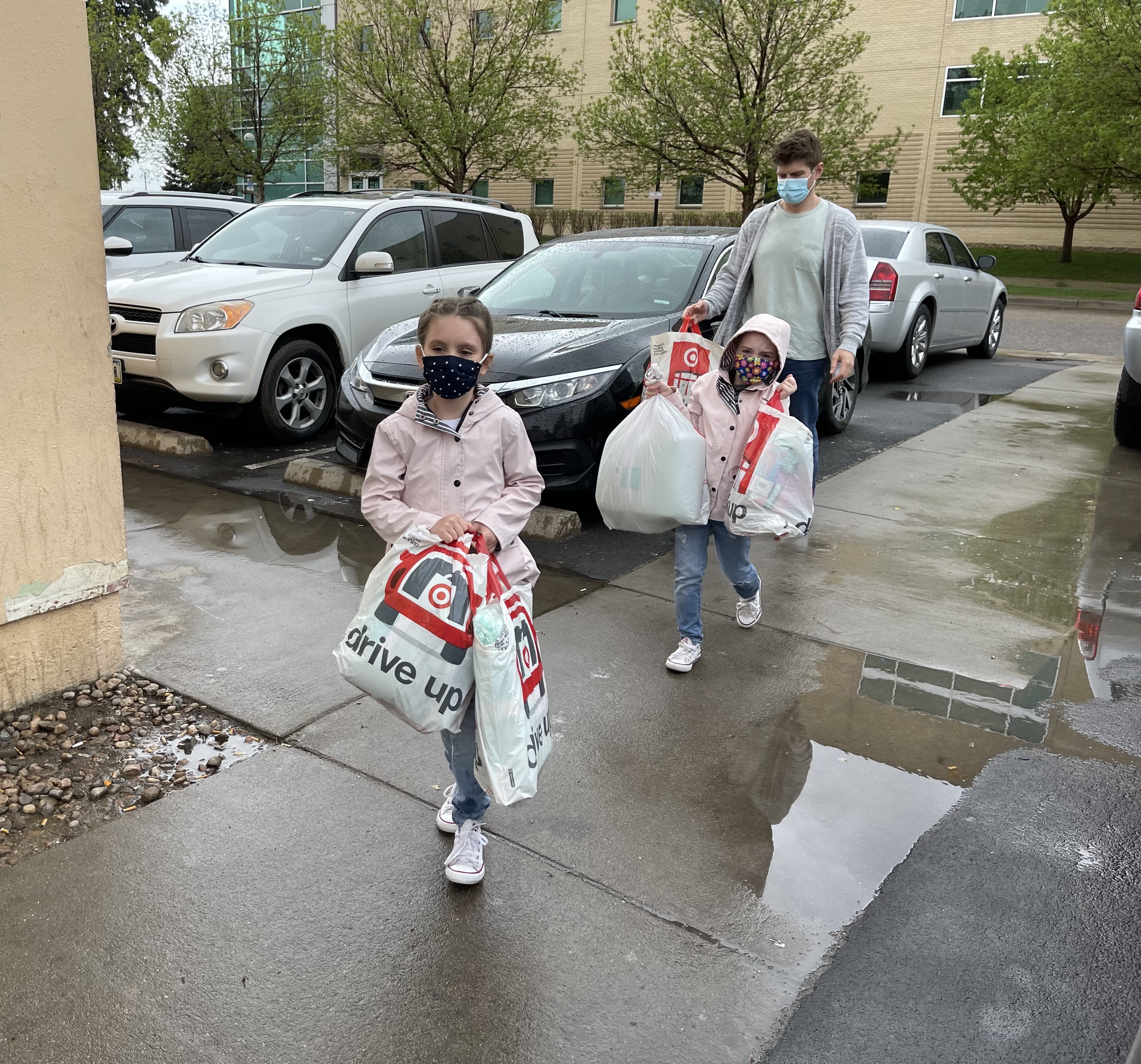 Grey, Nora and Joshua Giannotti carry bags of blankets to the Aurora Day Resource Center in Aurora during 