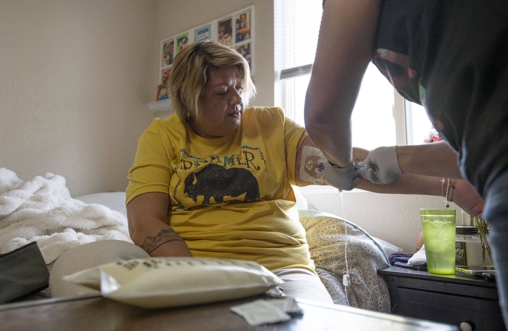 Brenna Logan, 37, helps her older sister Kendra Lippy, 38, change her TPN bag at Lippy's home in Colorado Springs on May 19, 2020. Logan helps her sister change her TPN bag every evening. The bag is needed so that Lippy can receive nutrients intravenously. (Chancey Bush/ The Gazette) (Chancey Bush/ The Gazette)