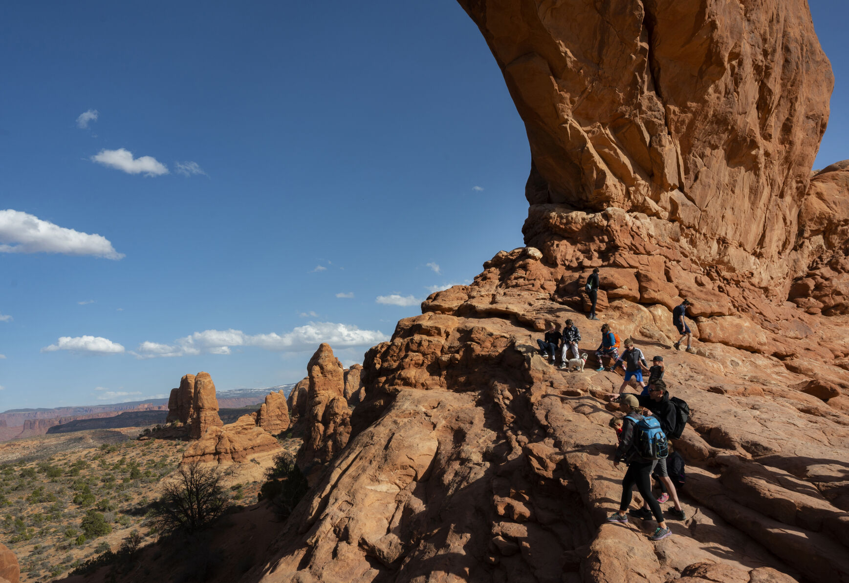 Hikers climb on the North Window Saturday, March 20, 2021, in the Windows Section of Arches National Park outside Moab, Utah. (The Gazette, Christian Murdock) (The Gazette, Christian Murdock) (Christian Murdock/The Gazette)