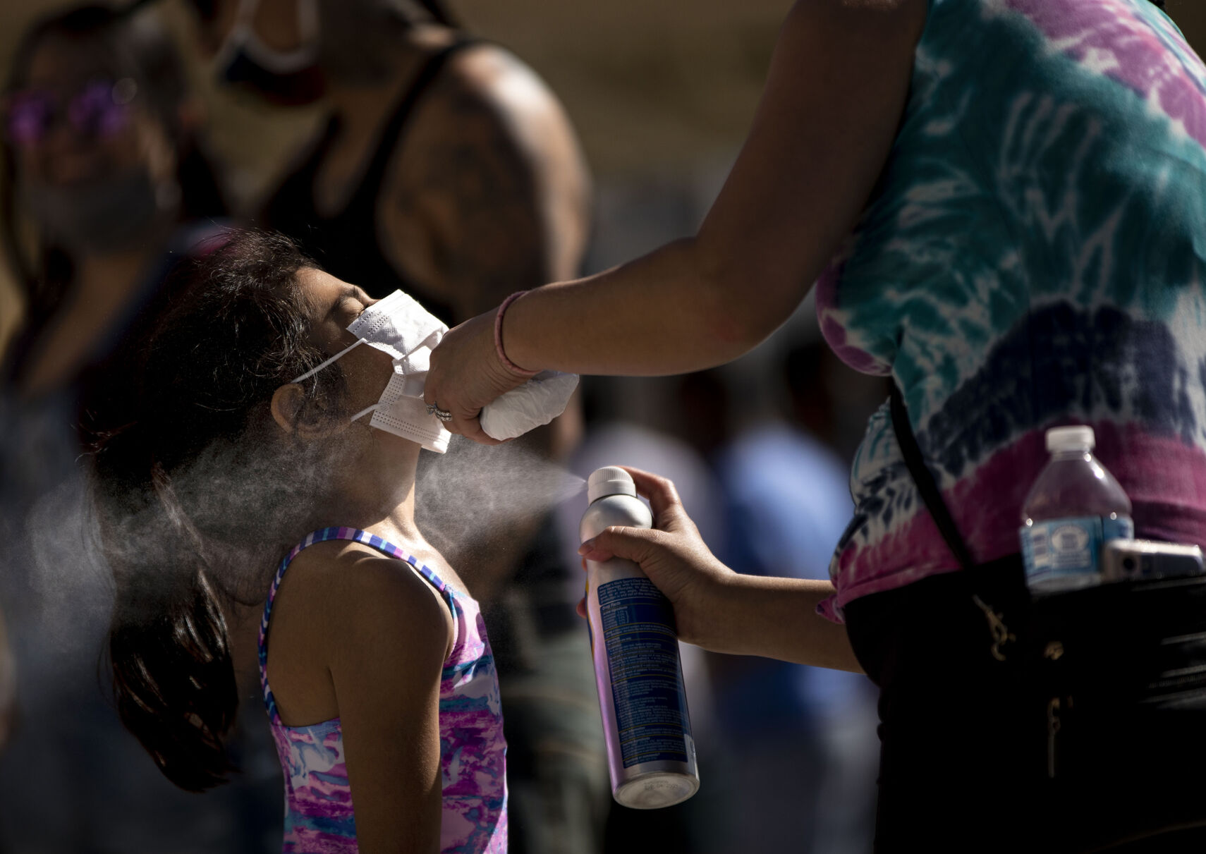 Juanita Segura puts sunscreen on Julianna Lucero, 5, as they wait in line for opening day at Elitch Gardens in Denver, Colo., on Saturday, May 1, 2021. The amusement park opened for the first time since Nov. 3, 2019, at 43% of their normal capacity without the water park. (Chancey Bush/ The Gazette) (Chancey Bush/ The Gazette)