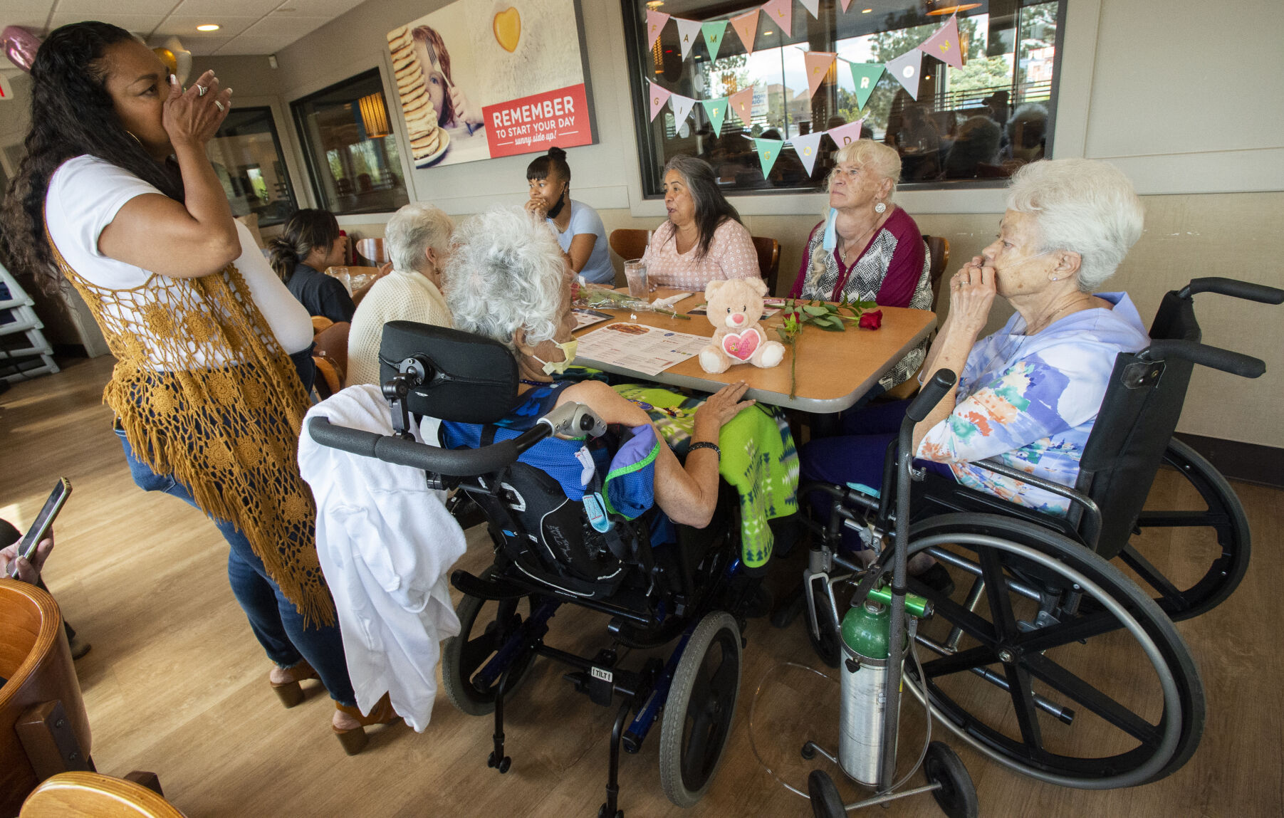 Virginia Garduño’s daughter Rae-Gina Anderson, standing, wipes a tear as she watches her mother gather with her new family and old family and friends for a meal on Wednesdayat an IHOP in Colorado Springs. (Photos by Christian Murdock, The Gazette)