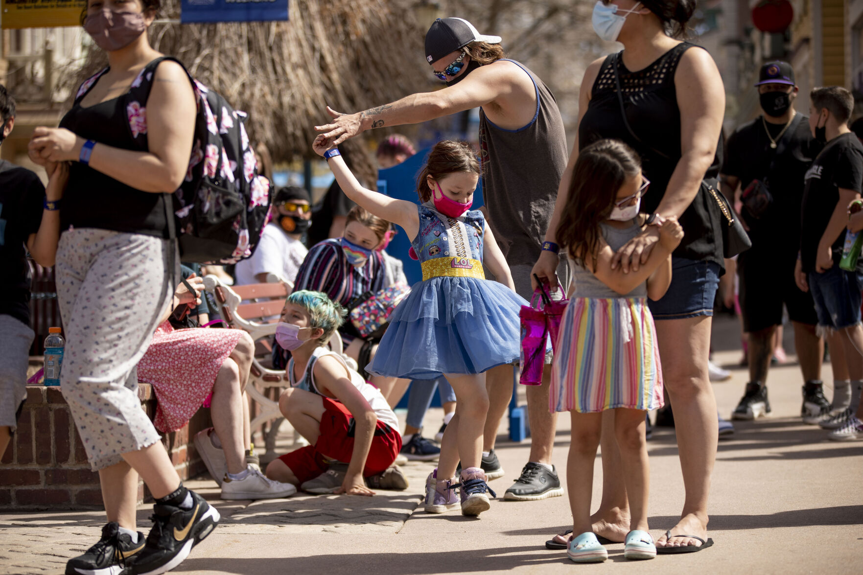 Bill Melka dances with his daughter Keira Melka, 6, as they wait for the rides to open during opening day at Elitch Gardens in Denver, Colo., on Saturday, May 1, 2021. The amusement park opened for the first time since Nov. 3, 2019, at 43% of their normal capacity without the water park. (Chancey Bush/ The Gazette) (Chancey Bush/ The Gazette)