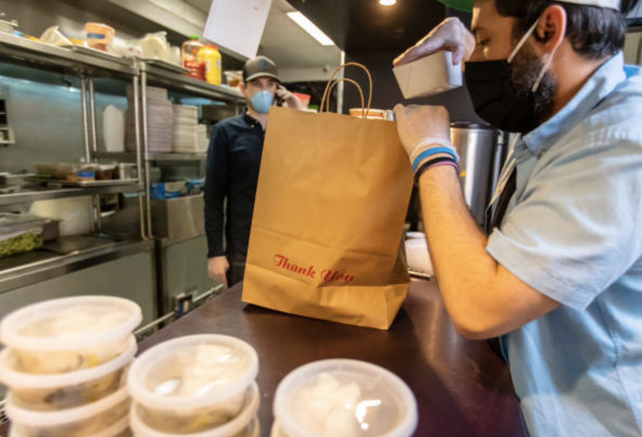 Owners of local restaurant taking orders on the phone and boxing food for delivery during the COVID-19 pandemic. (halbergman/ Getty Images)
