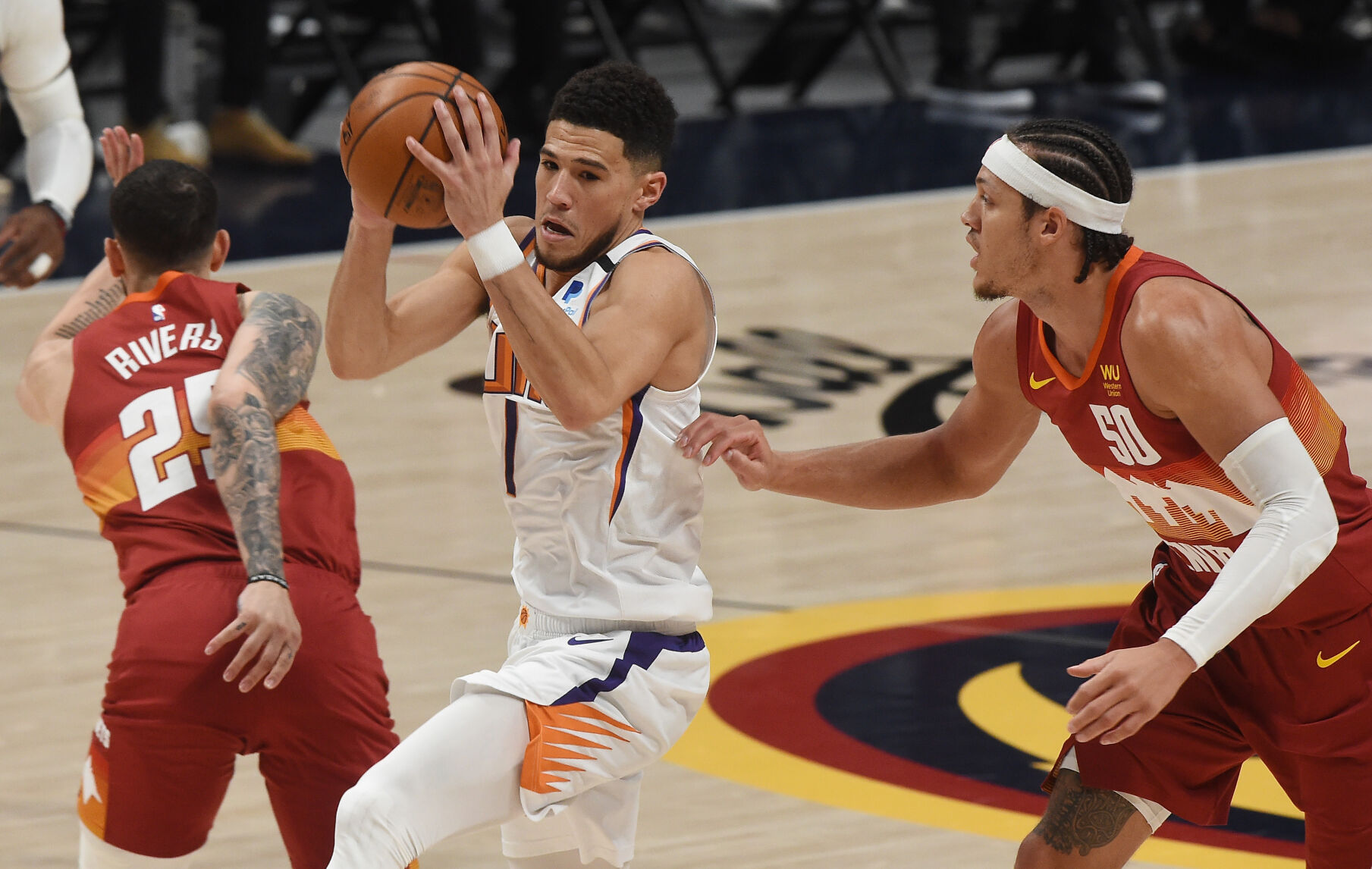 Phoenix’s Devin Booker goes between Denver’s Austin Rivers and Aaron Gordon during the first quarter of game 4 of the conference semifinals at Ball Arena on Sunday, June 13, 2021. (Photo by Jerilee Bennett, The Gazette) (JERILEE BENNETT)