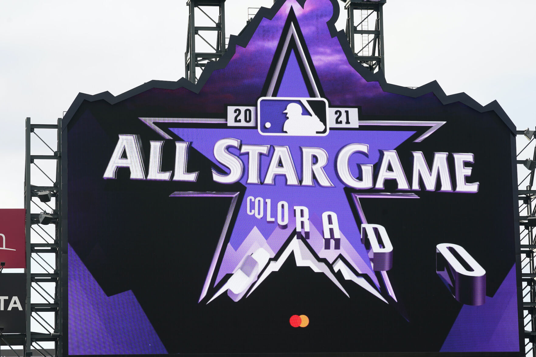 The logo for the 2021 Major League Baseball All star Game is revealed on the scoreboard before the first inning of a baseball game between the Philadelphia Phillies and the Colorado Rockies Friday, April 23, 2021, in Denver. ((AP Photo/David Zalubowski))