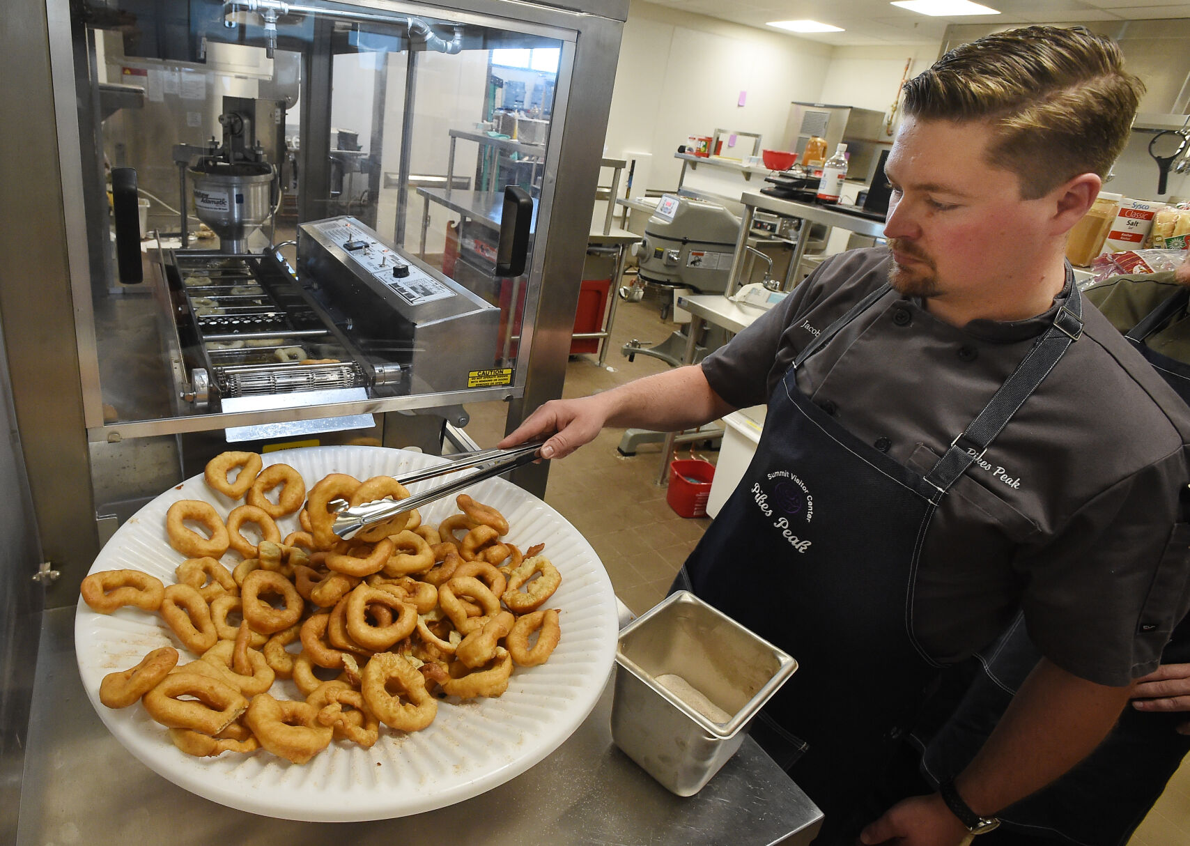 Summit House chef Jacob Leithner makes doughnuts at the new Pikes Peak Summit Complex using the old recipes from the 1920s during a June 14 media event. Many fans were concerned about the doughnuts staying a Pikes Peak summit tradition. (JERILEE BENNETT, THE GAZETTE)
