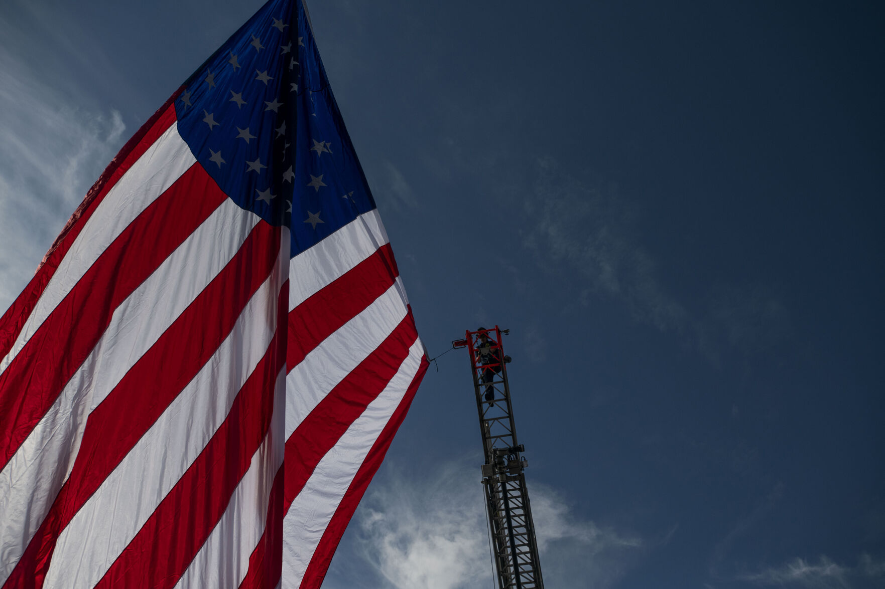 Lafayette fire fighter prepares to take down the honor flag after the procession for slain Arvada police officer Gordon Beesley passed through in Lafayette, Colo., on Tuesday, June 29, 2021. A funeral was held at the Flatirons Community Church for officer Beesley, who was a 19-year veteran of the Arvada Police Department. Officer Beesley was killed by a gunman in Olde Town Arvada plaza on June 21, 2021. (Chancey Bush/ The Gazette) (Chancey Bush)