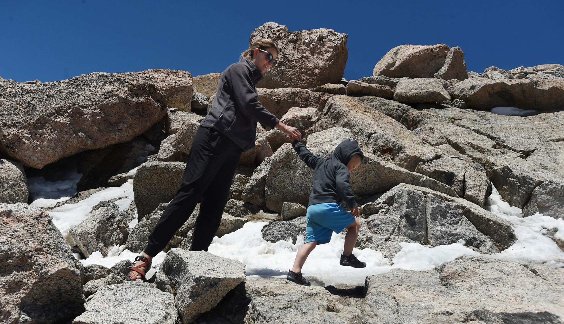 Ryden Krause takes lead while holding hands with mom, Erin Krause, on Wednesday, June 9, 2021, on the way to the summit of Mt. Evans. Last Summer the highway to the summit of Mt. Evans was closed to motorized vehicles due to Covid concerns. The road is back open this summer, but paid reservations must be made ahead of time online at recreation.gov. (Photo by Jerilee Bennett, The Gazette) (JERILEE BENNETT)