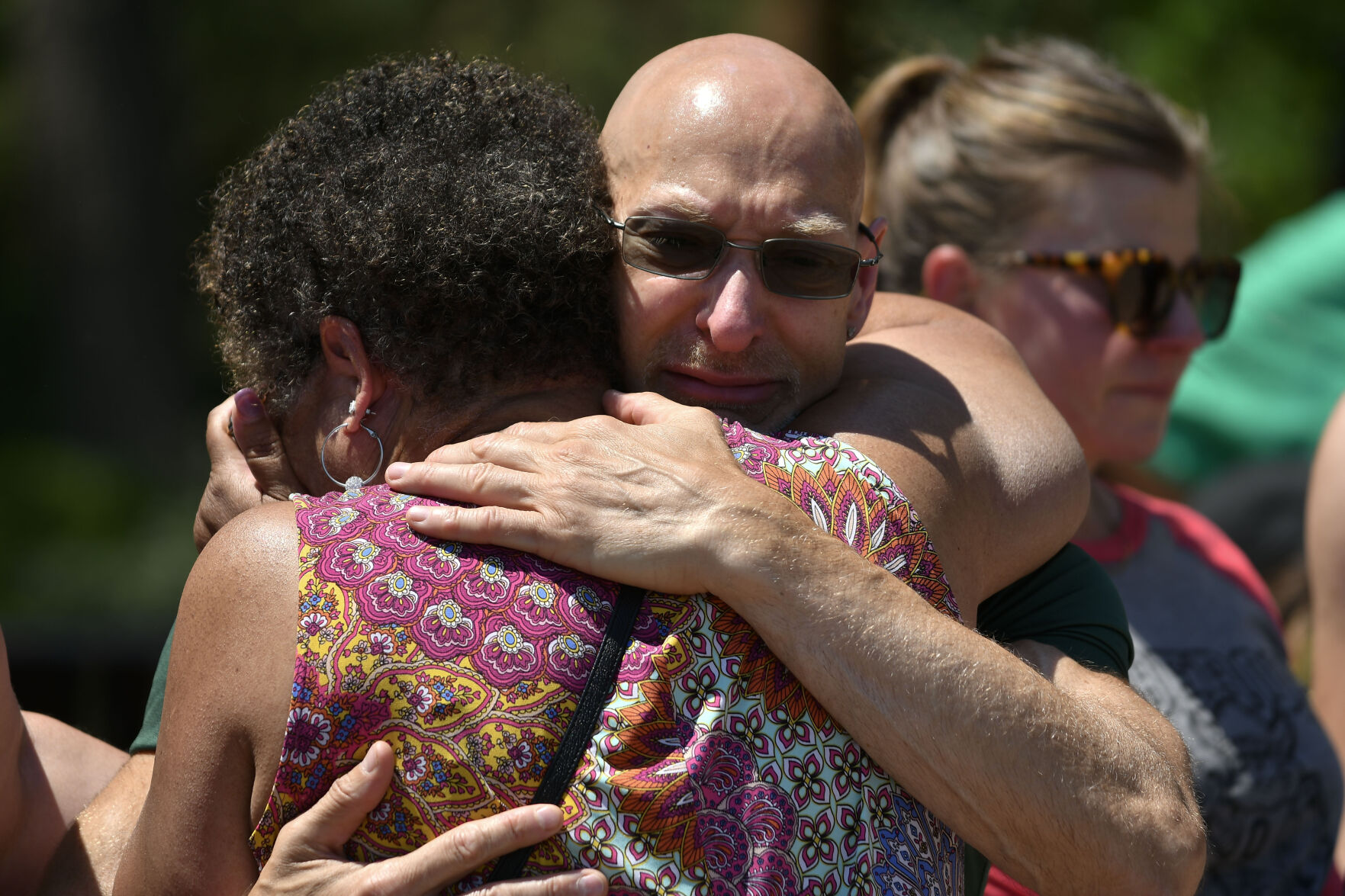 JUNE 22, 2021 - David Ruppert, Counselor at Oberon Middle School embraces a former staff member Melinda Perry, Social Worker at the school, as they gather at the fountain in Old Town Arvada where a shooting left three people dead, including Arvada veteran police officer Gordon Beesley, another person was also killed after being shot by the gunman and the suspect was also shot and killed. The staff from Oberon Middle School marched to the police station where the officers patrol car is on display covered with flowers and several flags. (Photo by John Leyba) (John Leyba)