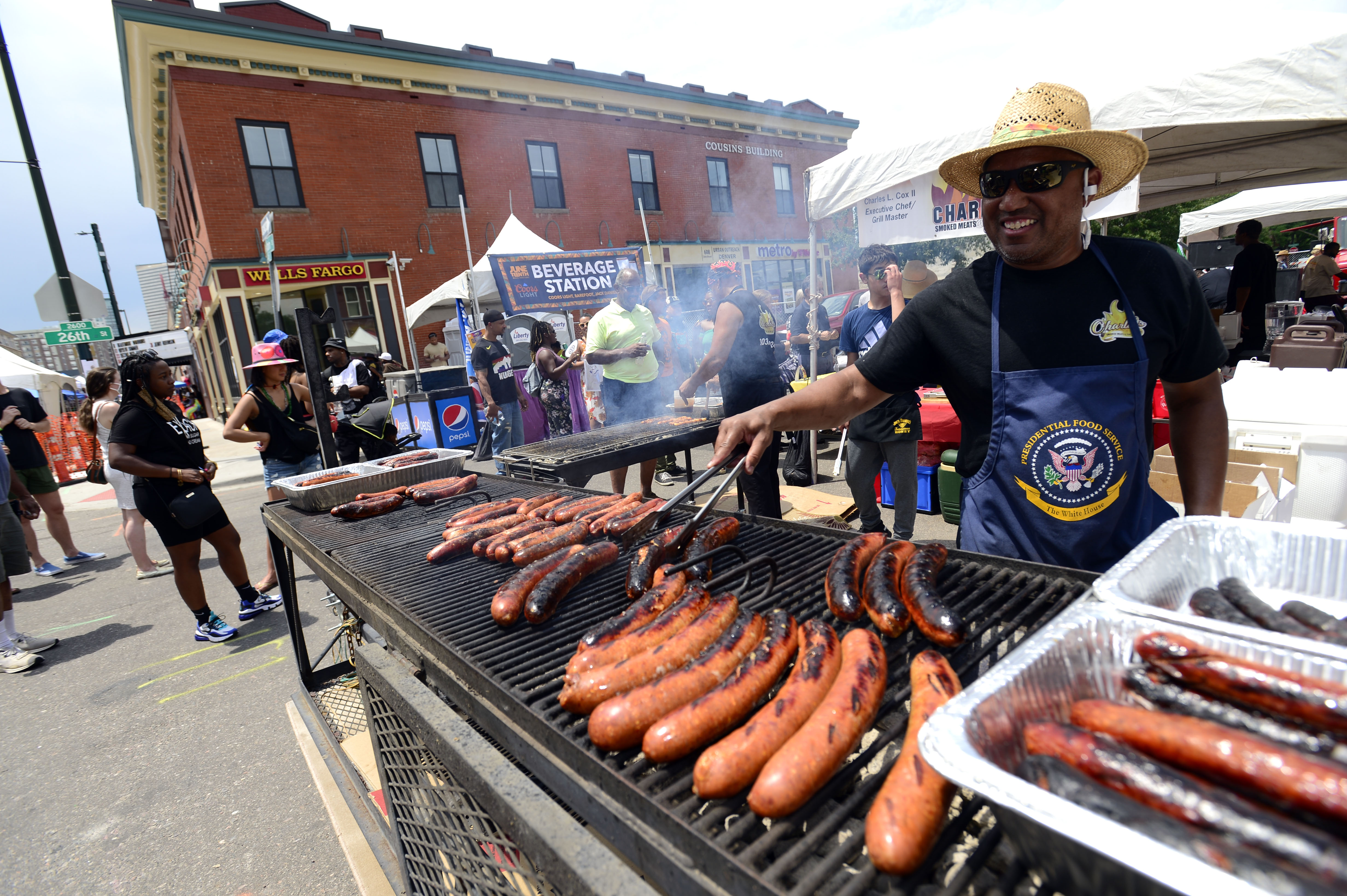 JUNE 19, 2021 - John Cato of Carlies Smoked Meats tends the polish sausages as Denver kicked off Juneteenth with the annual parade march from Manual High School to Five Points where there were well over 200 booths lining Welton Street. The Street Festival is open 2-8 p.m over the weekend with food, music and live entertainment. Juneteenth is celebrated each year on June 19 and commemorates the end of chattel slavery in the U.S., and now Congress has voted to mark the date as a federal holiday. (Photo by John Leyba) (John Leyba)