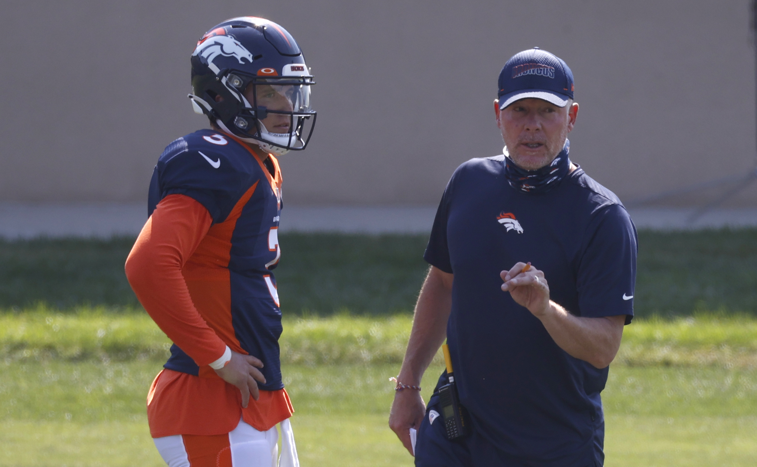 Broncos offensive coordinator Pat Shurmur, right, confers with quarterback Drew Lock as he takes part in drills Aug. 17 in Englewood. (The Associated Press)