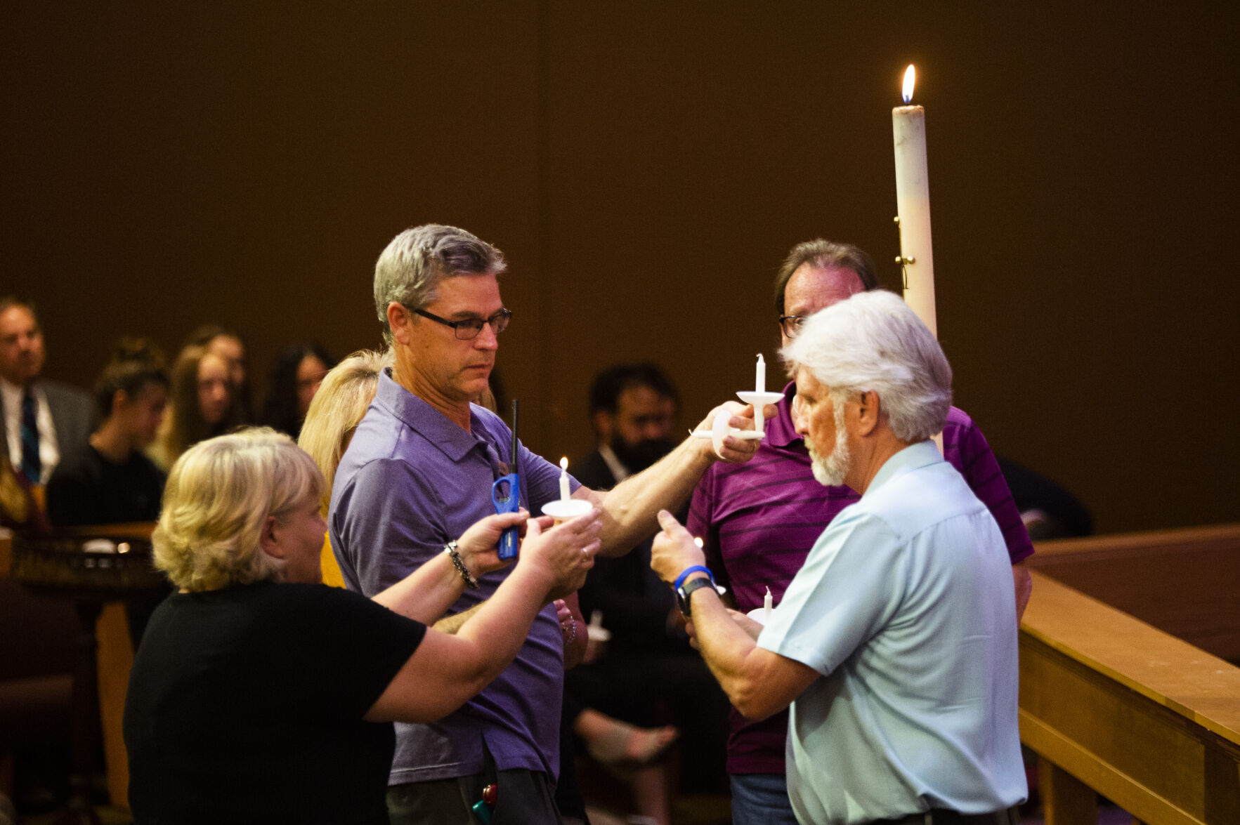 Community members help each other light candles during a community vigil for fallen Officer Gordon Beesley on Tuesday, June 22, 2021 at Peace Lutheran Church in Arvada, Colo. (Katie Klann/The Denver Gazette) (Katie Klann The Gazette)