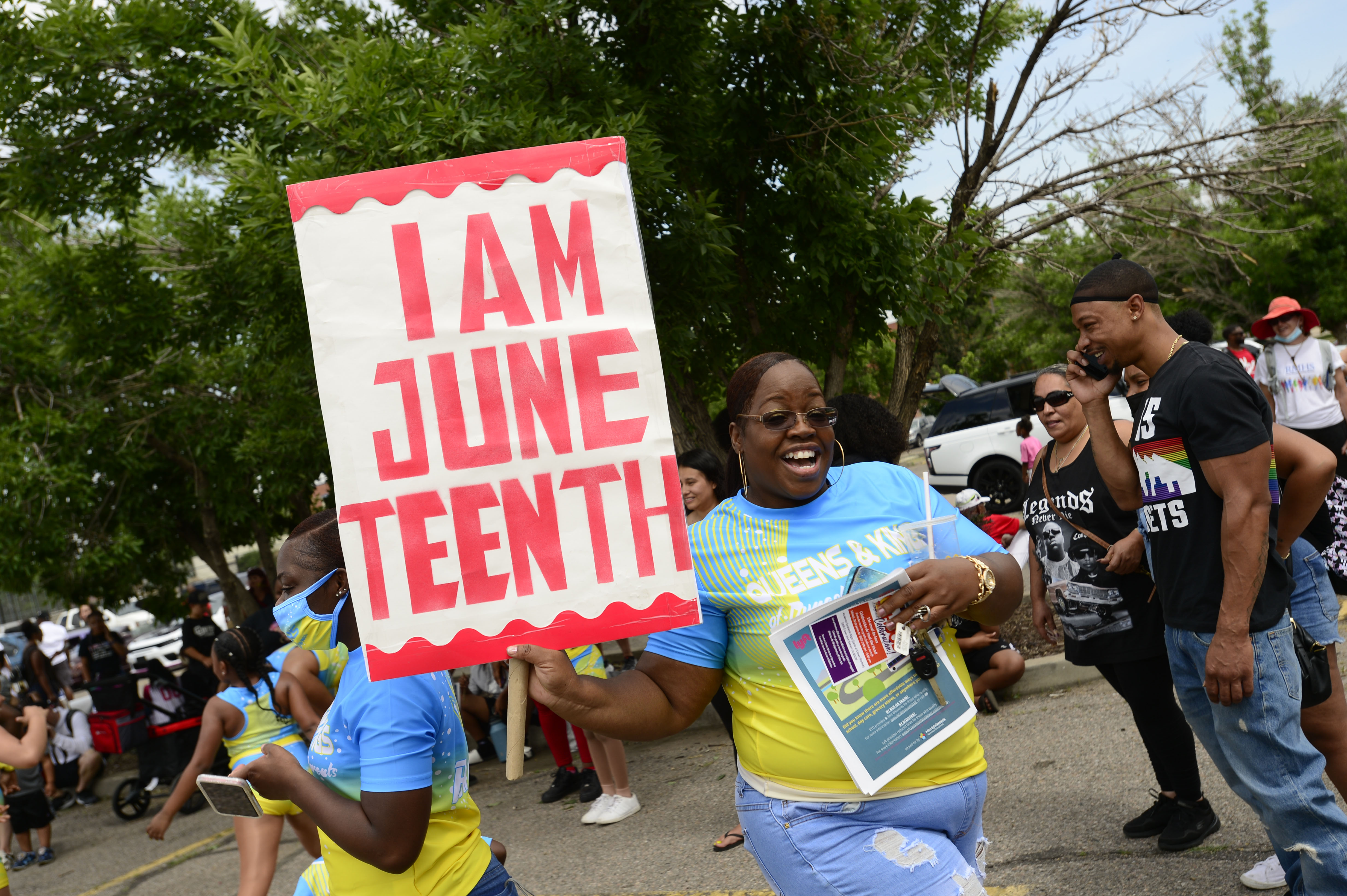 JUNE 19, 2021 - Tia Sims with Queen & Kings of Dynasty Dance Parents poses with her sign at the staging area at Manual High School. Denver kicked off Juneteenth with the annual parade march from Manual High School to Five Points where there were well over 200 booths lining Welton Street. The Street Festival is open 2-8 p.m over the weekend with food, music and live entertainment. Juneteenth is celebrated each year on June 19 and commemorates the end of chattel slavery in the U.S., and now Congress has voted to mark the date as a federal holiday. (Photo by John Leyba) (John Leyba)