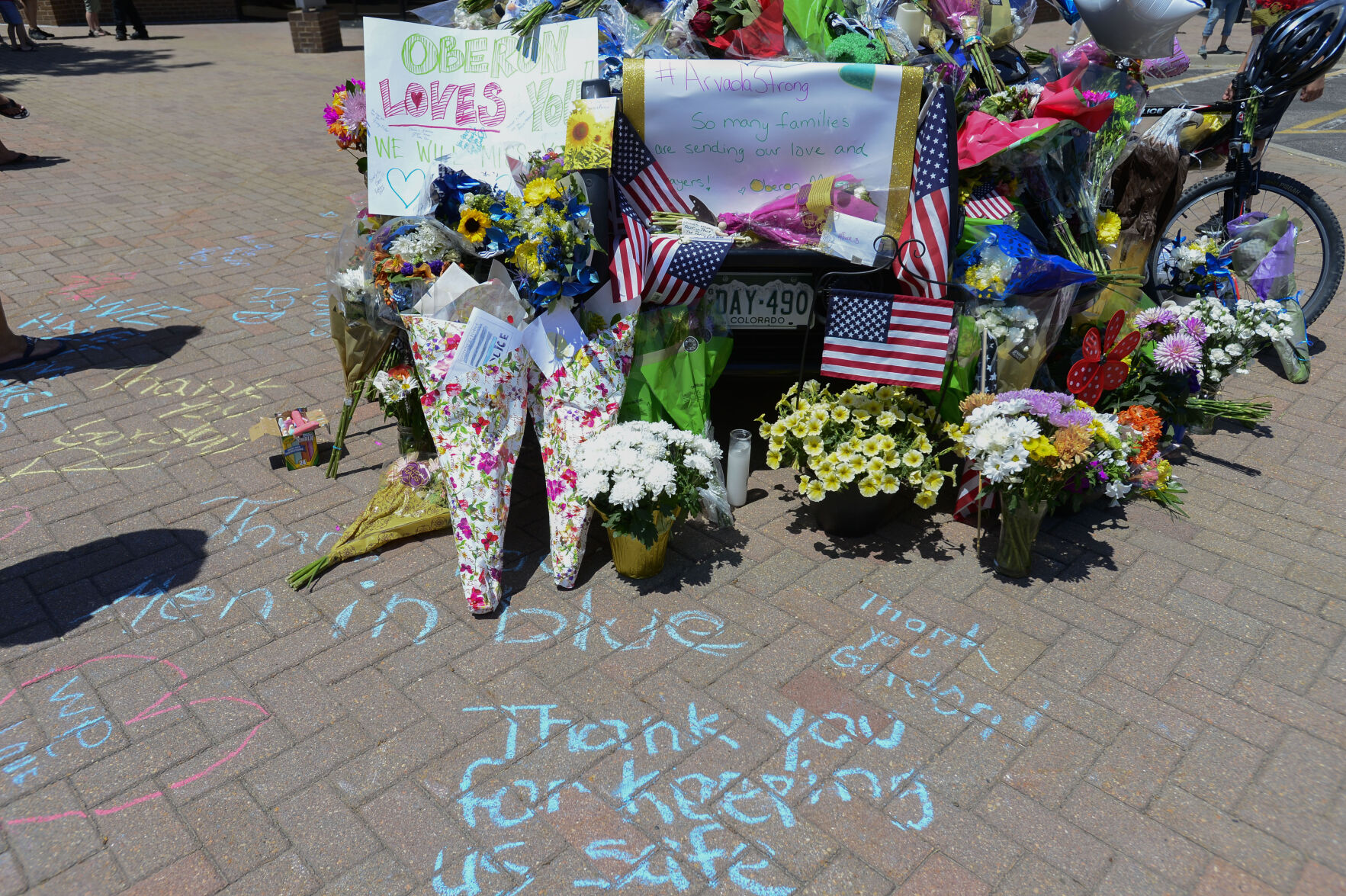 JUNE 22, 2021 - The police station where the officers patrol car is on displayed is covered with flowers and several flags as the memorial grows. Staff members from Oberon Middle School gathered at the station to pay their respects. Beesley was a Resource Officer at Oberon Middle School. The shooting took place in Olde Town Arvada where the shooting left three people dead, including Arvada veteran police officer Gordon Beesley, another person was also killed after being shot by the gunman and the suspect was also shot and killed. (Photo by John Leyba) (John Leyba)