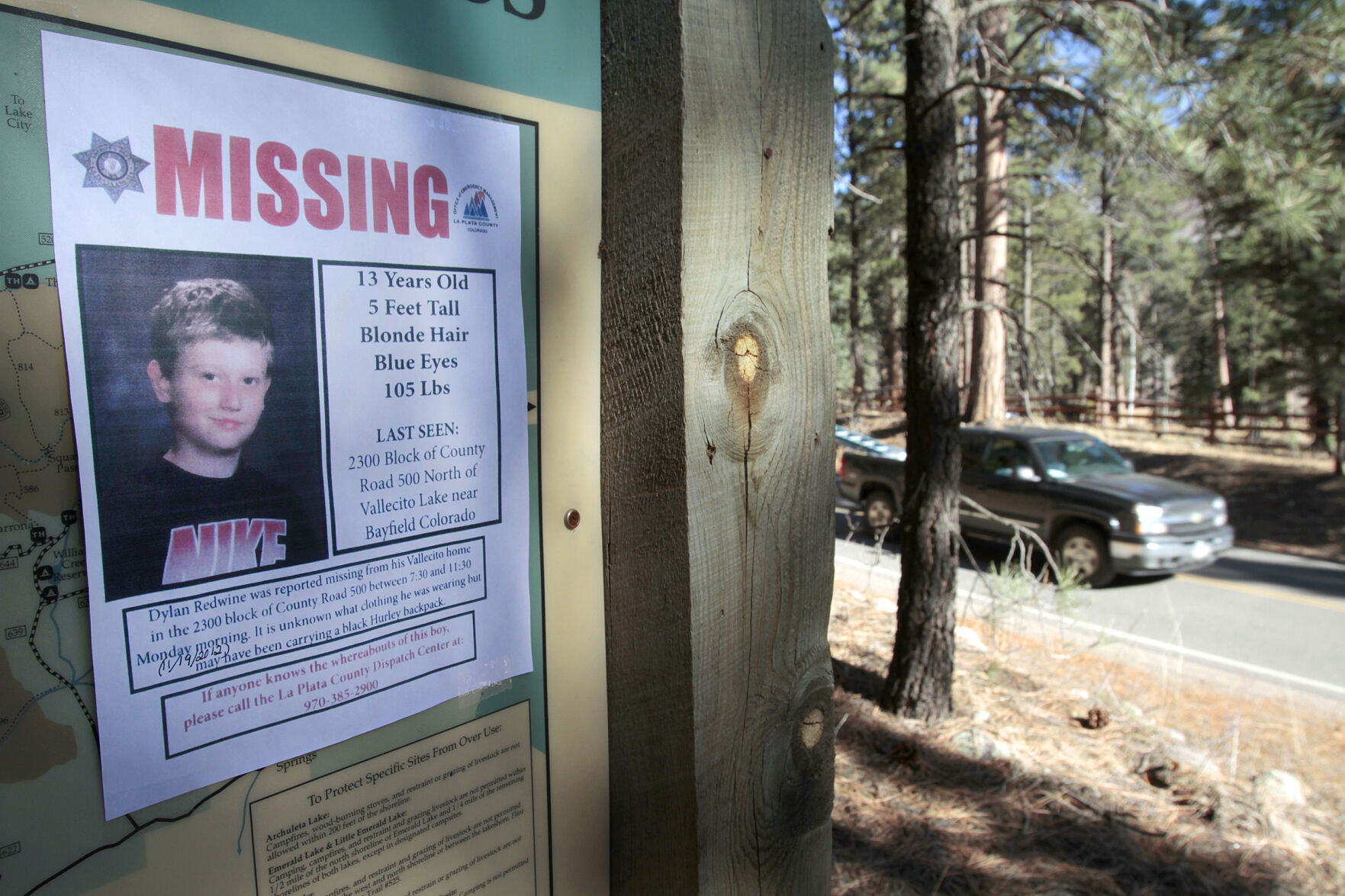 FILE - In this Nov. 26, 2012, file photo, a missing poster of 13-year-old Dylan Redwine hangs on a trail head sign next to Vallecito Reservoir in Vallecito, Colo. Opening statements are expected sometime Monday, June 21, 2021, in the delayed trial of a man accused of killing his 13-year-old son in southwest Colorado nearly a decade ago. Dylan Redwine disappeared during a court ordered Thanksgiving visit in 2012 and his remains were later found. (Shaun Stanley/The Durango Herald via AP, File) (Shaun Stanley)