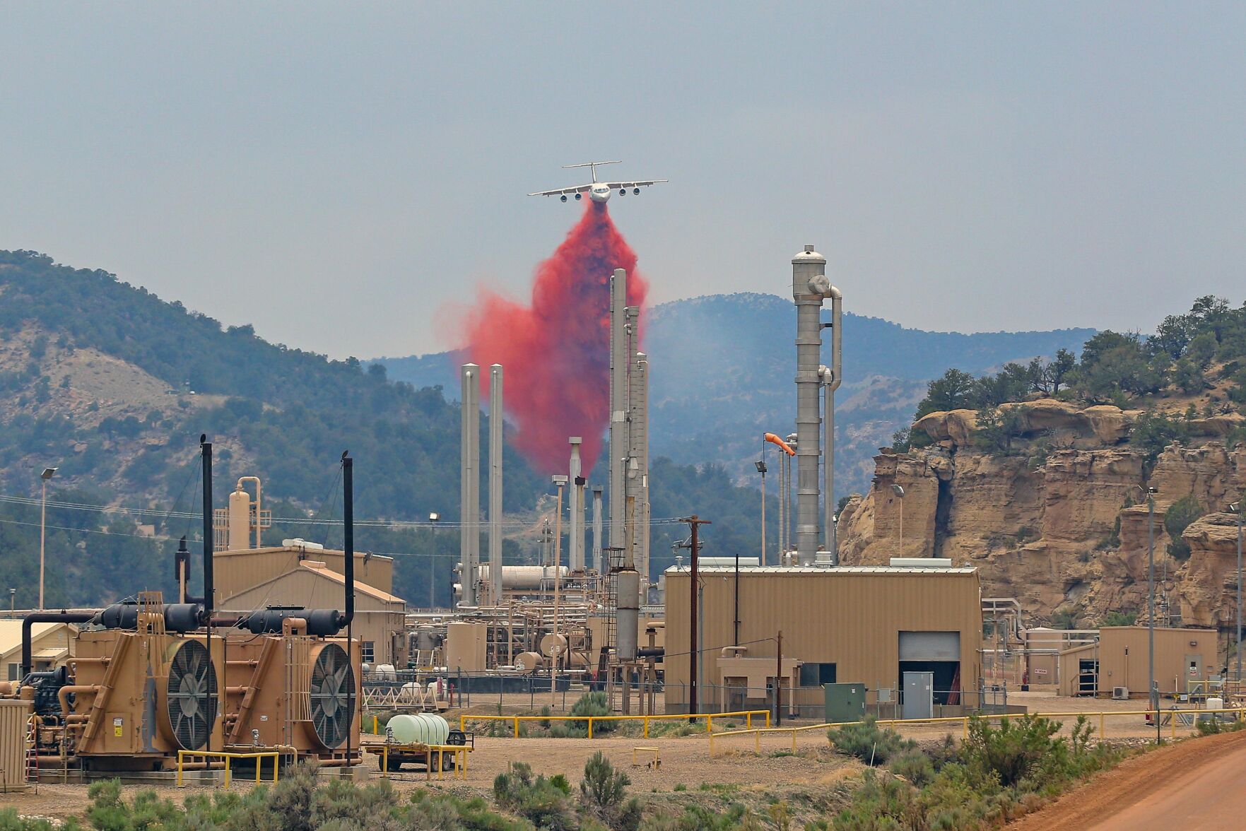 A large air tanker drops retardant near a natural gas plant as part of an effort to protect the plant from the Oil Springs Fire south of Rangely, Colorado. Retardant did not cover the plant. (White River Field Office)