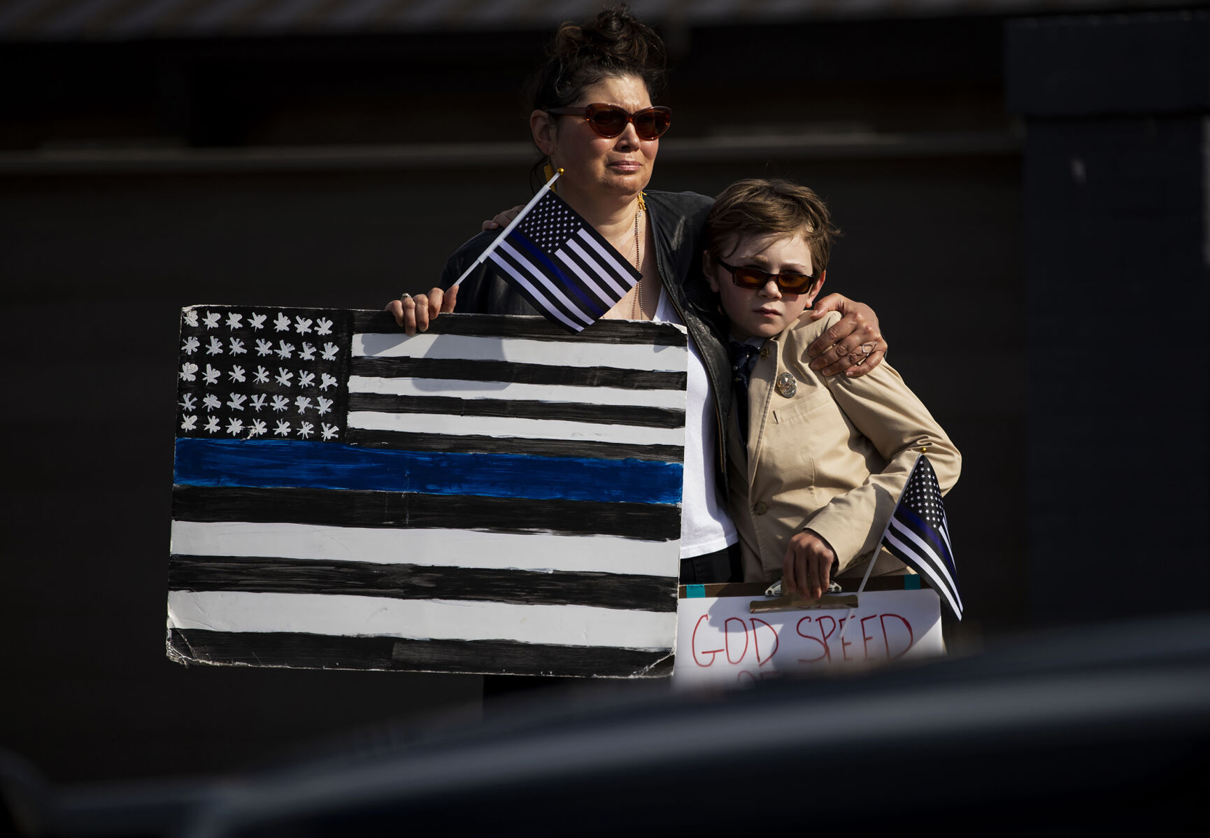 Susan Gilmore and her son Gil Gilmore, 10, pay their respects as hundreds of law enforcement and first responder vehicles pass by during a funeral procession for slain Arvada police officer Gordon Beesley in Lafayette, Colo., on Tuesday, June 29, 2021. A funeral was held at the Flatirons Community Church for officer Beesley, who was a 19-year veteran of the Arvada Police Department. Officer Beesley was killed by a gunman in Olde Town Arvada plaza on June 21, 2021. (Chancey Bush/ The Gazette) (Chancey Bush)