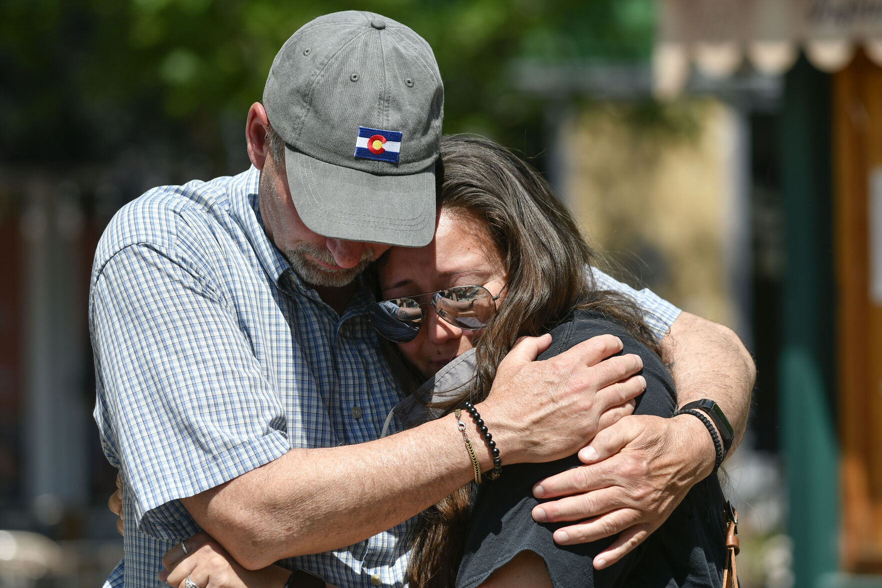 JUNE 22, 2021 - Staff members from Oberon Middle School embrace as they gather at the fountain in Olde Town Arvada where a shooting left three people dead, including Arvada veteran police officer Gordon Beesley, another person was also killed after being shot by the gunman and the suspect was also shot and killed. The staff from Oberon Middle School marched to the police station where the officers patrol car is on display covered with flowers and several flags. (Photo by John Leyba) (John Leyba)
