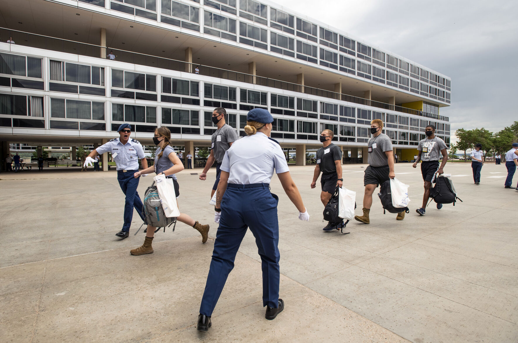 Incoming cadets run from the footprints as cadre members yell at them to hurry up during In-Processing Day at the United States Air Force Academy in Colorado Springs, Colo., on Thursday, June 24, 2021. Over 1,100 incoming freshman will undergo six weeks of basic training before officially becoming cadets.(Chancey Bush/ The Gazette) (Chancey Bush/ The Gazette)