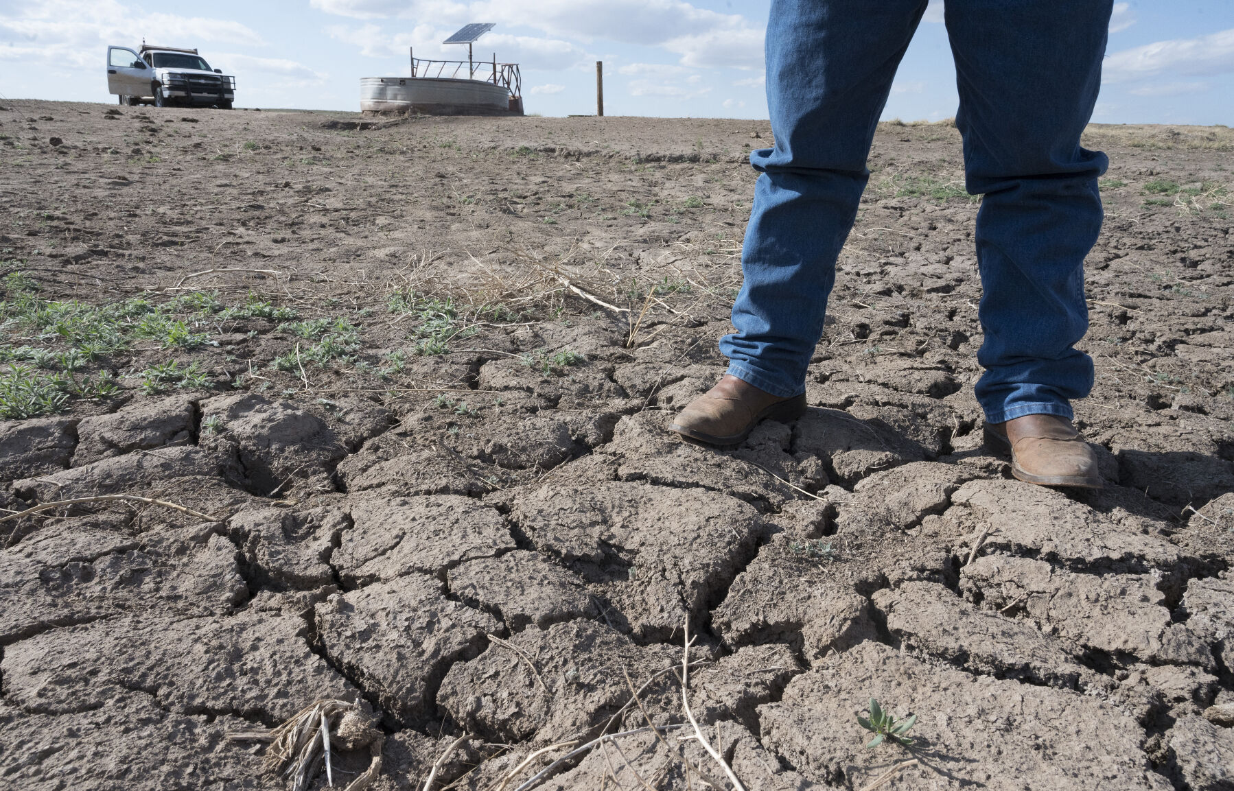 A rancher in Baca County stands on the parched ground that used to be a pond to water his cattle. He asked to remain anonymous. (PHOTOS BY JERILEE BENNETT, THE denver GAZETTE)