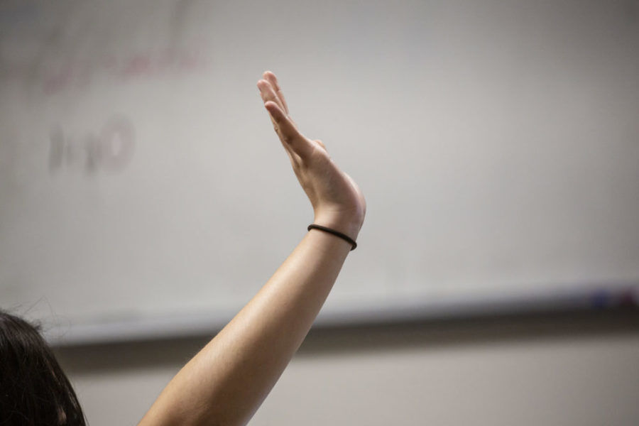 A student raises her hand at DCIS Montbello during a reading assignment in a classroom at the Denver school in May. ((Nathan W. Armes, Chalkbeat Colorado))