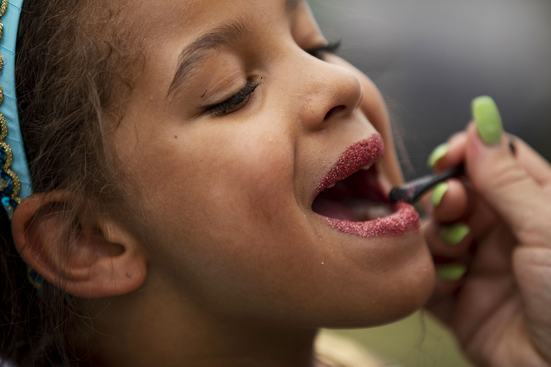 Noelle Luketu, 7, has glitter applied to her lips by her mother Miranda Sutherland during opening day of the 2021 Colorado Renaissance Festival in Larkspur, Colo., on July 3, 2021. The festival is back for their 44th season after being postponed by the COVID-19 pandemic last year. The Renaissance Festival is open for eight themed weekends, Saturdays and Sundays, through Aug. 22 in Larkspur, 650 W. Perry Park Ave. 10 a.m.-6:30 p.m. (Chancey Bush/ The Gazette) (Chancey Bush/ The Gazette)