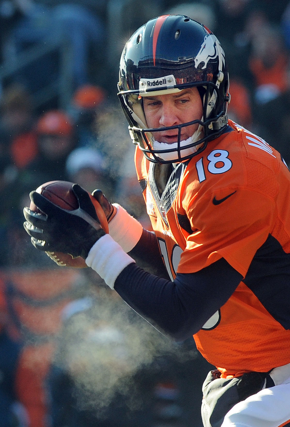 Broncos quarterback Peyton Manning's breath can be seen before handing off the ball during the first quarter of a game against the Tennessee Titans. The Broncos played the Titans at Invesco Field at Mile High Stadium on Sunday, December 8, 2013. . (The Gazette/Jerilee Bennett) (JERILEE BENNETT)