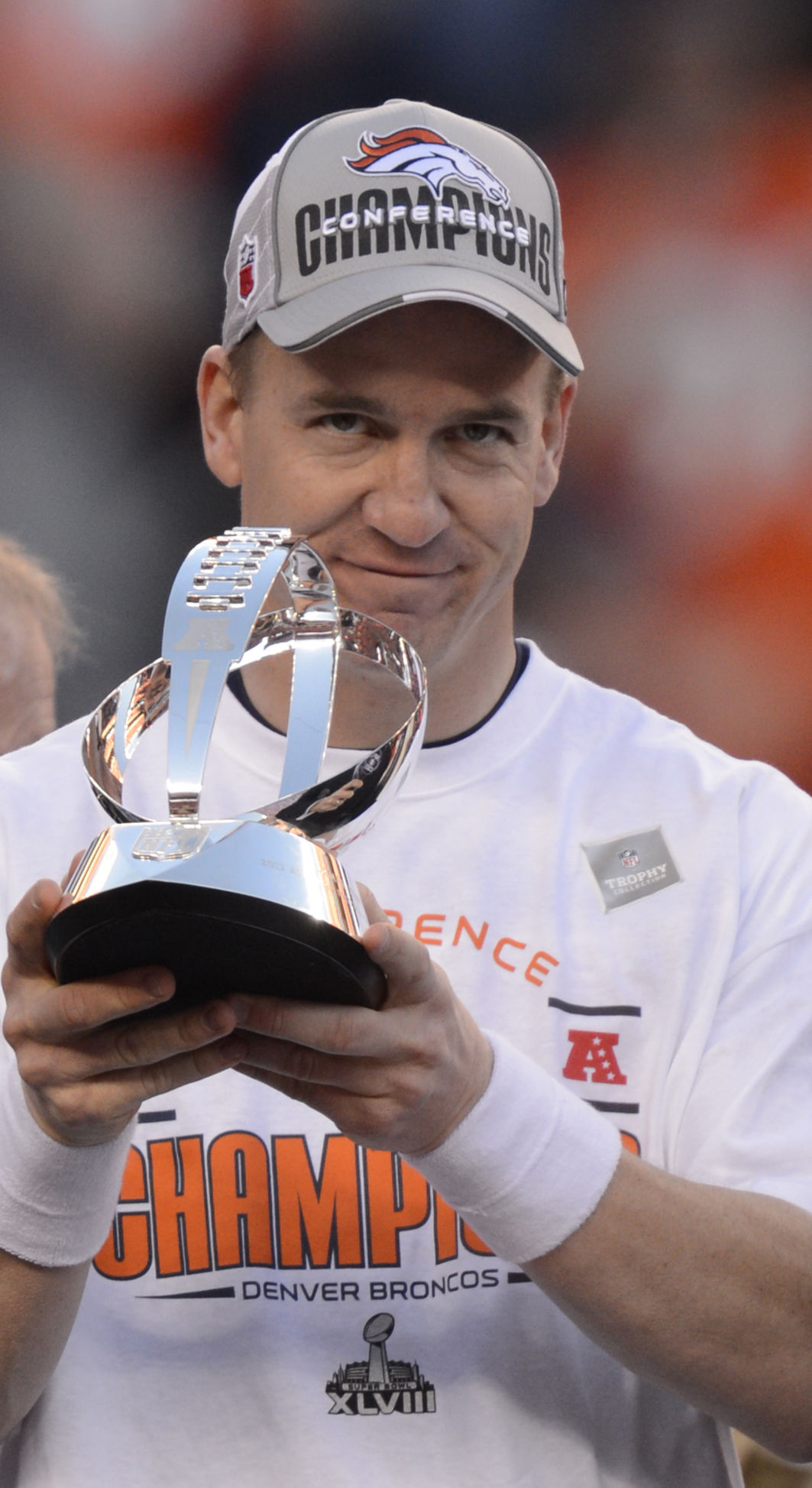 Peyton Manning holds the trophy after the Broncos 26-16 win over the Patriots in the AFC Championship game Sunday, January 19, 2014 at Sports Authority Field at Mile High. Photo by Mark Reis, The Gazette (MARK REIS)