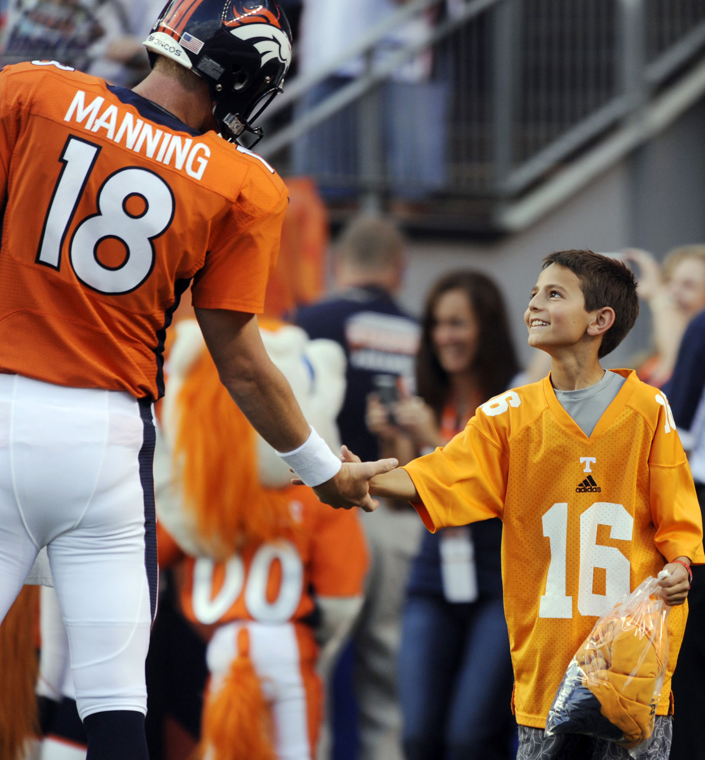 A youngster reaches to shake the hand of Denver Broncos quarterback Peyton Manning (18) before a preseason NFL football game against the Arizona Cardinals, Thursday, Aug. 29, 2013, in Denver. (AP Photo/Jack Dempsey) (Jack Dempsey)