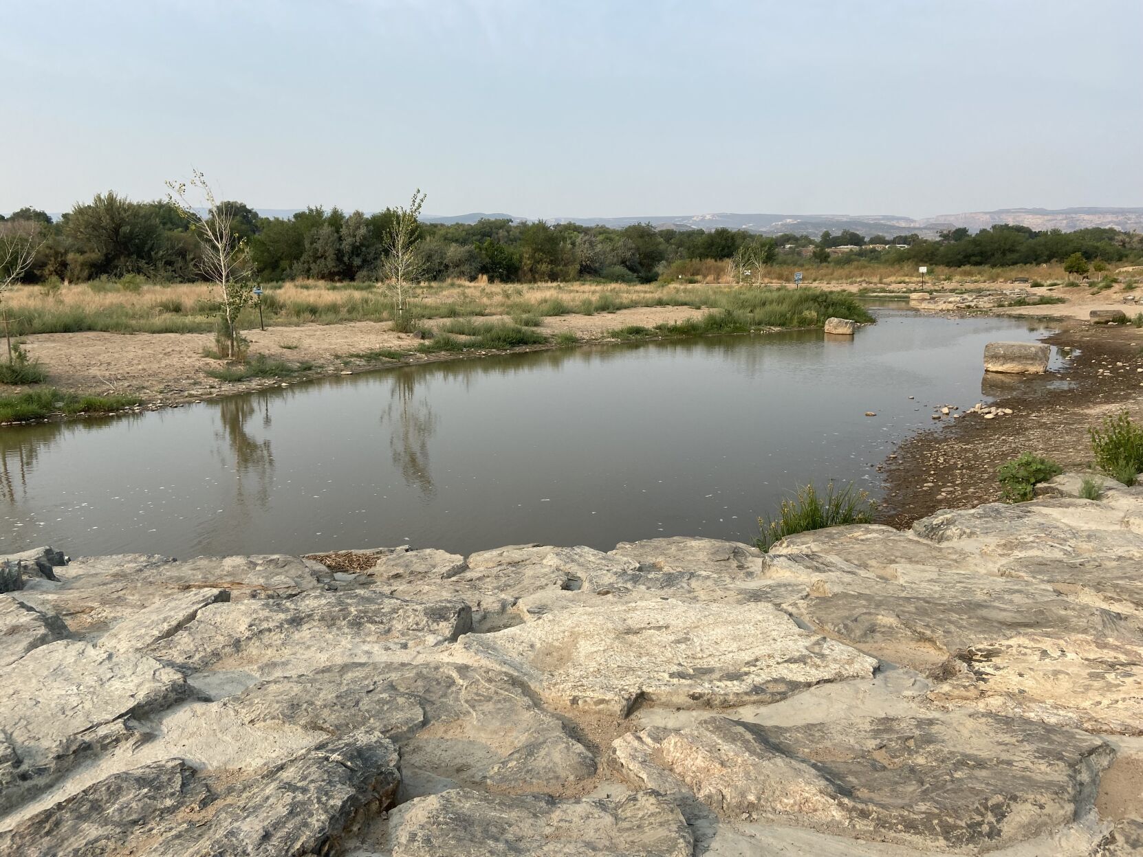 The 130-acre Las Colonias Park contains dog parks, the riverfront trail and a channel for recreation. The channel connects to the Colorado River, but is separated by sandbags to cut off flows when the water level drops in the river. (Michael Karlik, colorado politics)