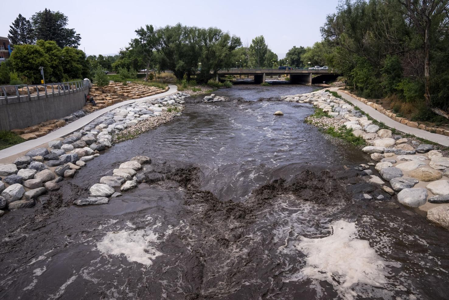 Katie Klann, the gazette The water runs dark at the Poudre River Whitewater Park on Wednesday, Aug. 4, in Fort Collins, made black by the runoff of charred earth eroded by rains after last summer’s Cameron Peak fire.Katie Klann, the gazette