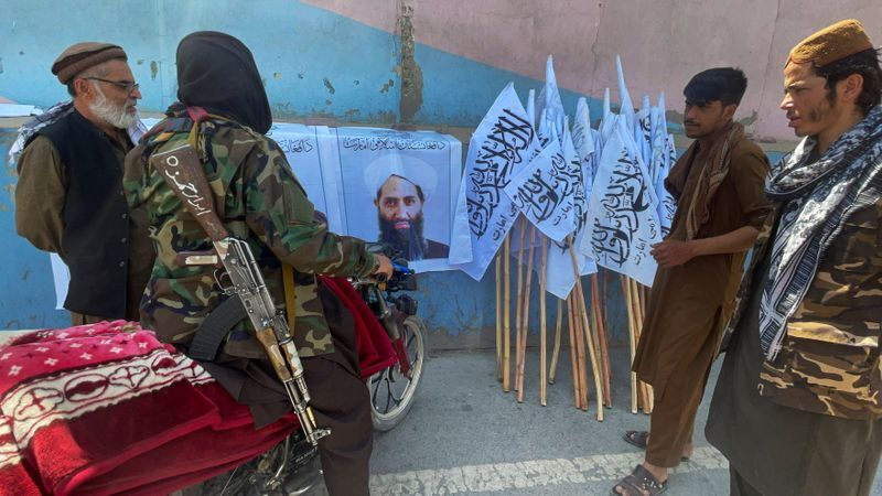 Members of Taliban forces gather and look at the picture of their leader Mullah Haibatullah Akhundzada, in Kabul, Afghanistan August 25, 2021. Picture taken August 25, 2021. REUTERS/Stringer (STRINGER)