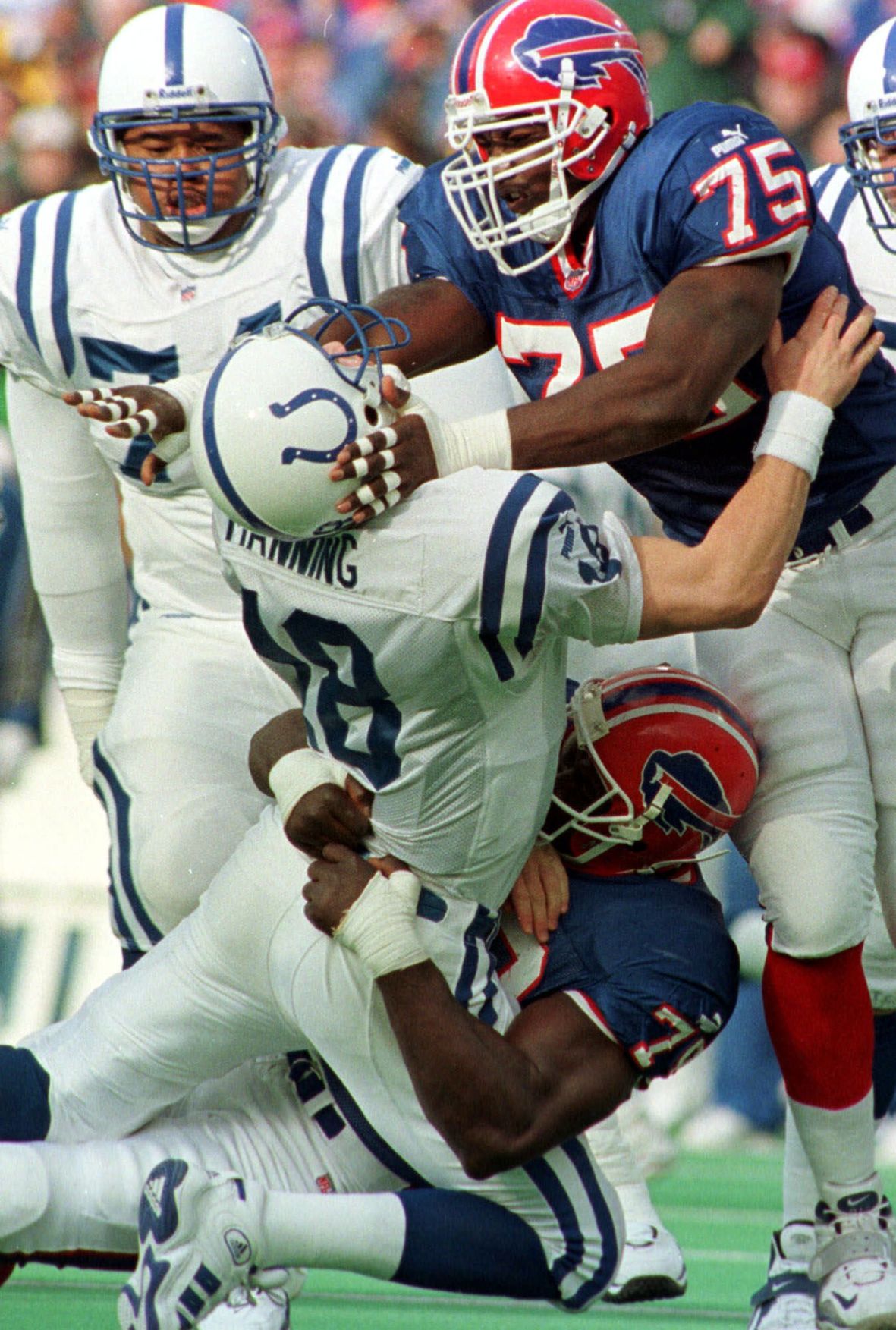 Indianapolis Colts quarterback Peyton Manning (18) is taken down by Buffalo Bills defensive ends Bruce Smith (78) and Marcellus Wiley (75) during the second quarter at Ralph Wilson Stadium, in Orchard Park, N.Y., Sunday, Jan. 2, 2000. The Bills were penalized for roughing the passer, eliminating an interception thrown by Manning on the play. (AP Photo/Don Heupel) (DON HEUPEL)
