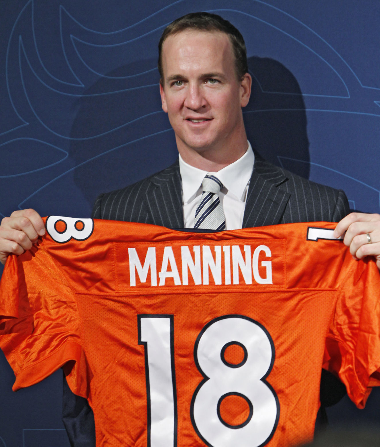 New Denver Broncos quarterback Peyton Manning holds a Broncos jersey with his name and number at the conclusion of an NFL football news conference at the Broncos headquarters in Englewood, Colo., on Tuesday, March 20, 2012. (AP Photo/Ed Andrieski) (Ed Andrieski)