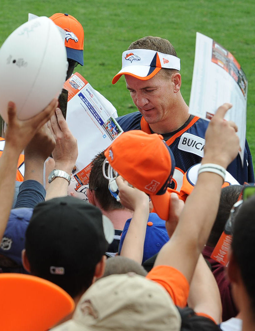 Denver quarterback Peyton Manning works feverishly to send as many fans home with his desired autograph as possible after Denver Broncos training camp. Manning was the most popular player for autograph seekers at Thursday's training camp.The Denver Broncos took to the field for the first day of training camp at Dove Valley on Thursday, July 25, 2013. (Jerilee Bennett/The Gazette) (JERILEE BENNETT)