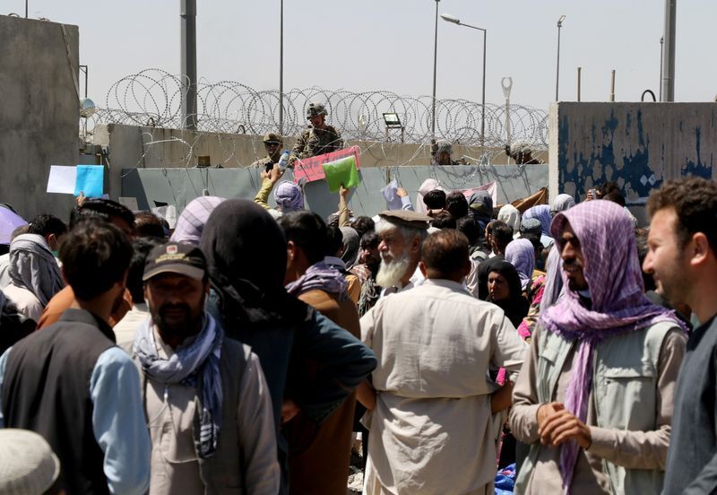Crowds of people show their documents to U.S. troops outside the airport in Kabul, Afghanistan August 26, 2021. REUTERS/Stringer (STRINGER)